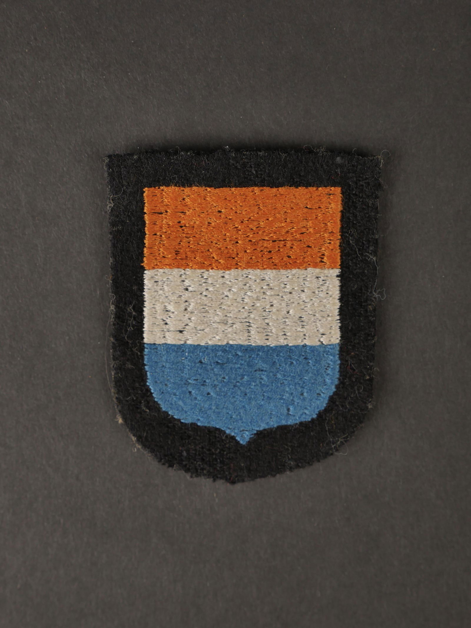Insigne SS hollandaise.Dutch SS badge.: Insigne de bras des volontaires hollandais dans la SS. Modele brode sur fond noir. Jamais monte. A noter une legere usure et patine de la piece. Etat I . More pictures on aiolfi.com. Arm badge of the