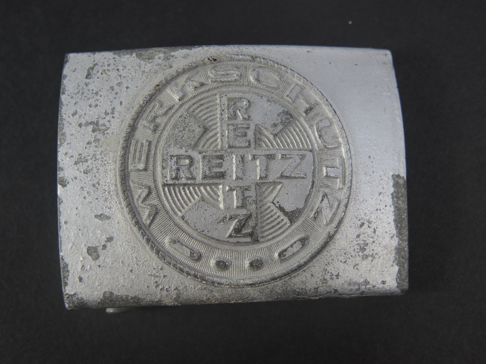 Boucle de ceinturon Werkschutz Reitz. Belt buckle Werkschutz Reitz.: Boucle de ceinturon Werkschutz Reitz. Boucle de ceinture extremement rare de la securite de l usine Reitz, produite dans l usine d uniformes Reitz en Belgique. En zinc laque argent. La couleur argent 