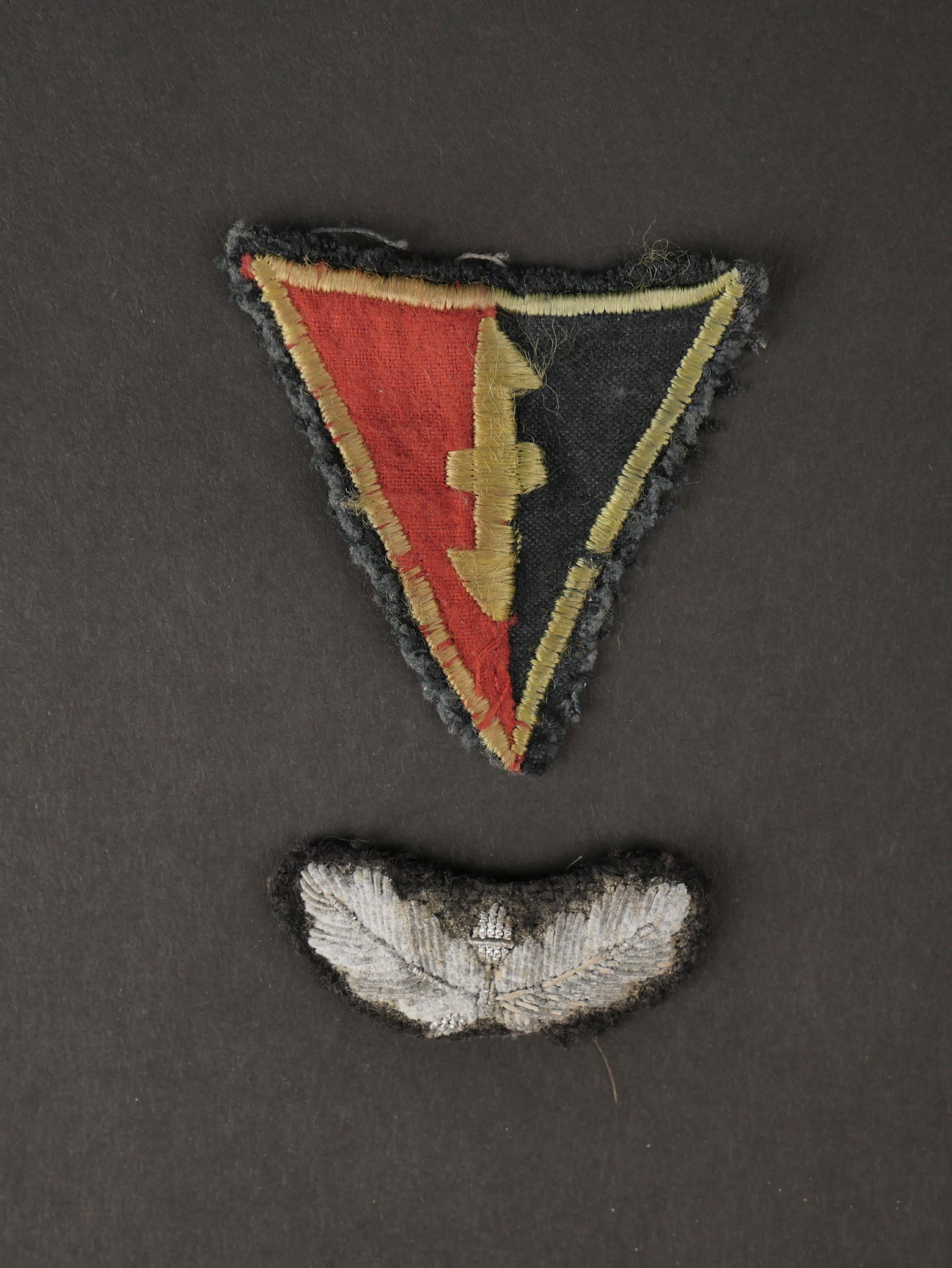 Insigne WA. WA badge.: Insigne de manche des troupes d assaut du NSB. En tissu rouge et noir, insigne centrale et bordure en fil or, visiblement demonte d une vareuse, on y joint une feuille de chene en cannetille argent, o