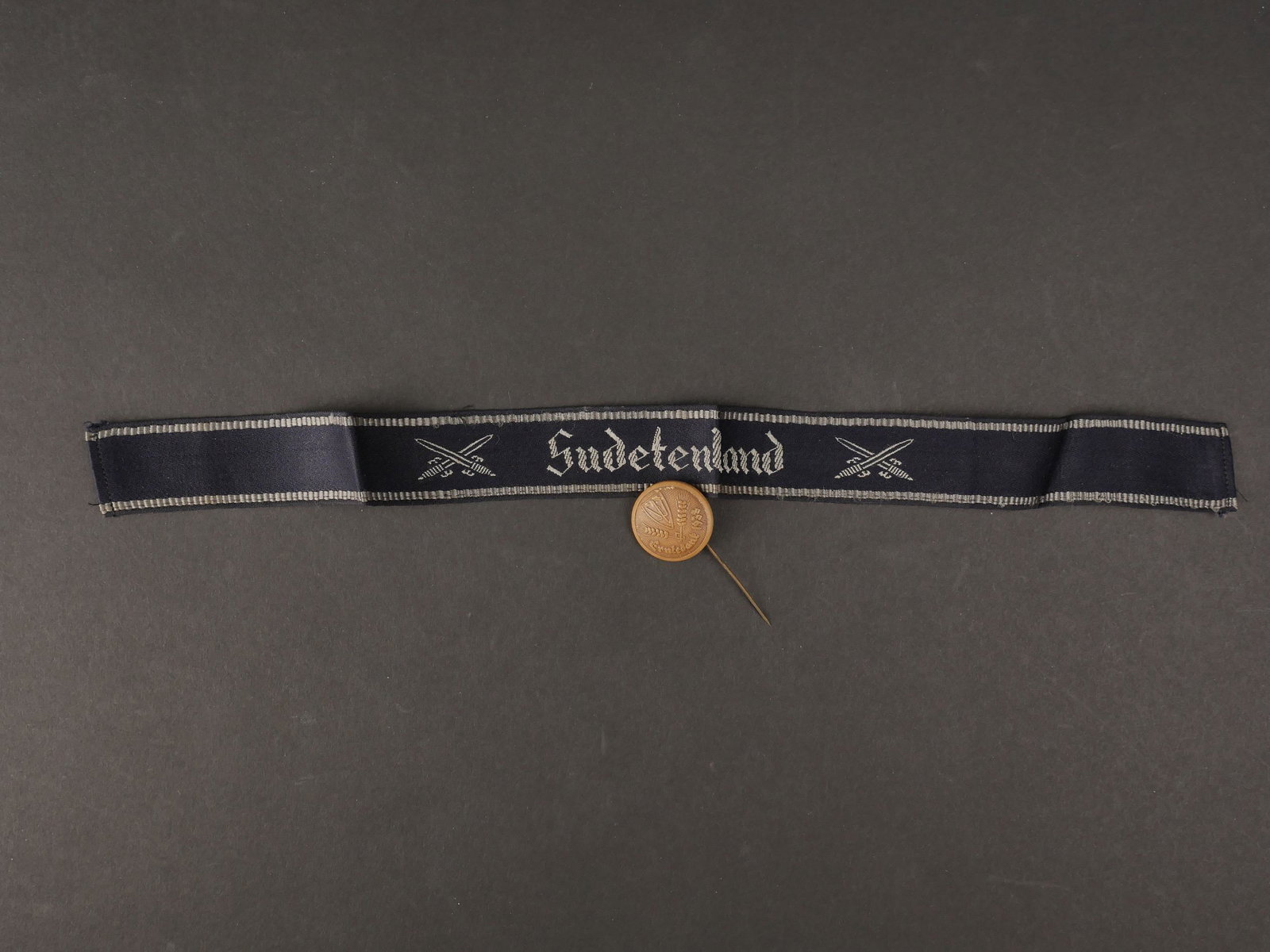 Bande de bras Sudetenland. Arm band Sudetenland.: Bande de bras Sudetenland. Fabrication Bevo, longueur 40 centimetres. On y joint une epinglette ronde en bois du personnel feminin des Sudetes de 1938. Sudetenland arm band, Bevo manufacture, length 4