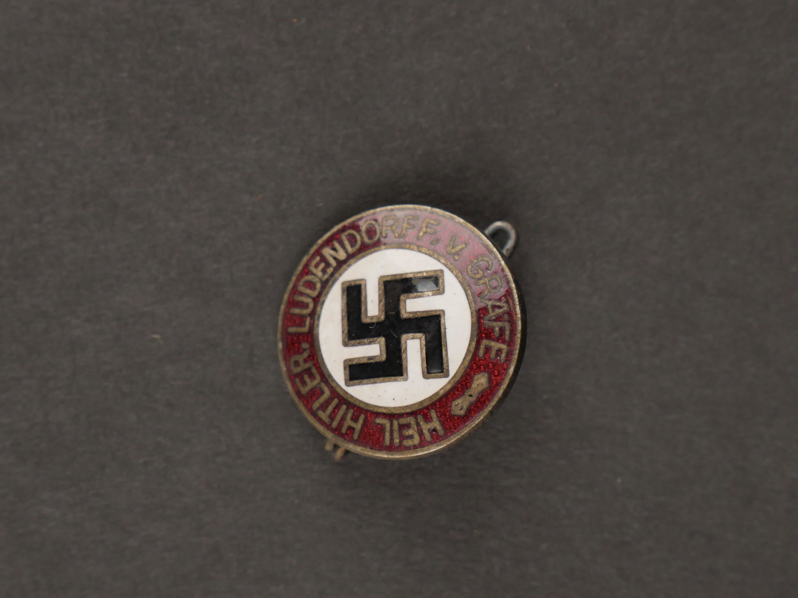 Insigne NSDAP. NSDAP badge.: Insigne NSDAP. En metal emaille. Bien marque Heil Hitler Ludendorff Grafe. Attache complete. Fabrication RZM M1/4, correspondant au fabricant Karl Gutenkunst Oranienburg. A noter une certaine usure et