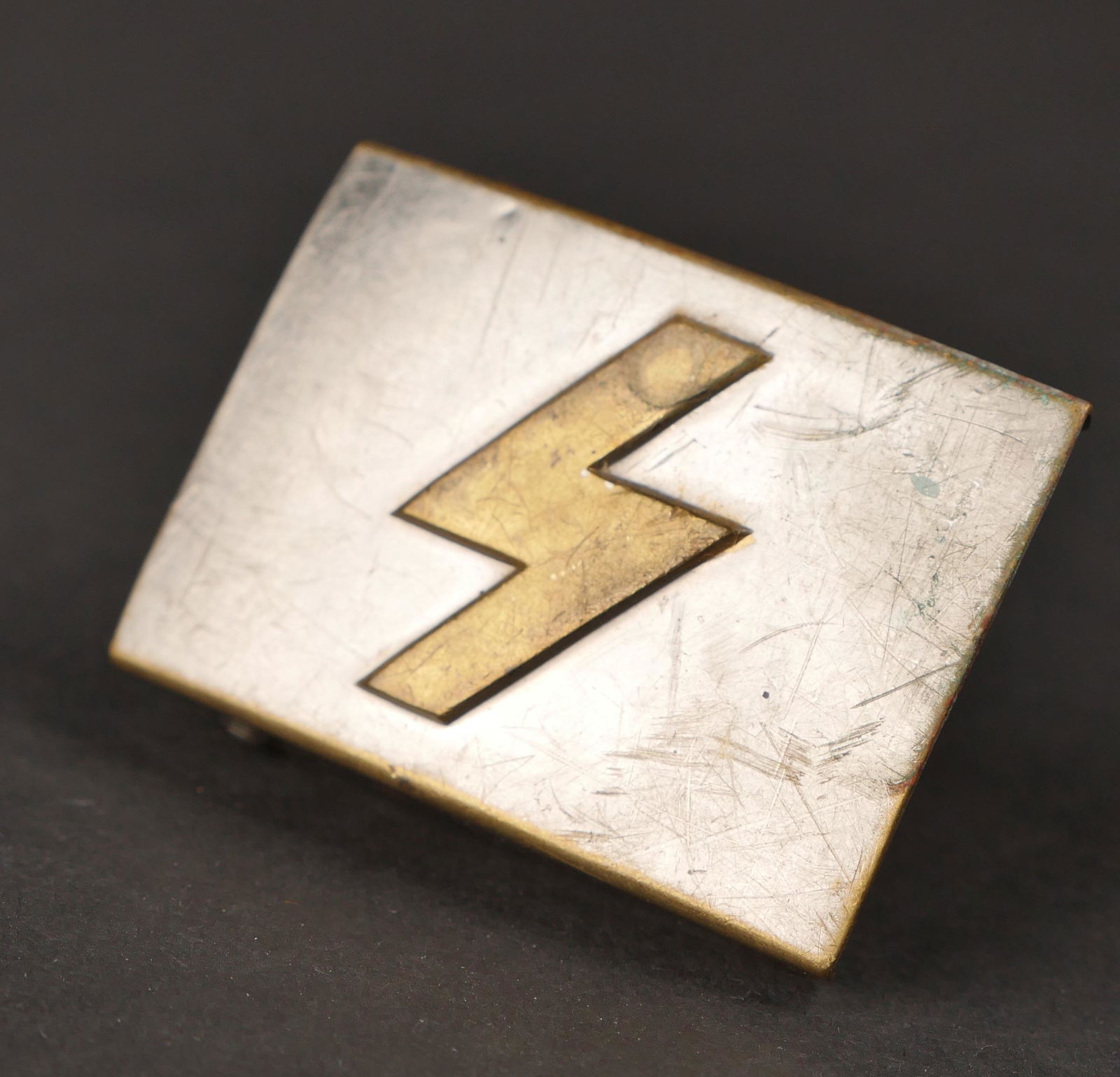 Boucle de ceinturon DJ. DJ belt buckle.: Boucle de ceinturon DJ. En aluminium. Insigne runique en relief. Boucle a deux ardillons complete. Petit modele. A noter une certaine usure et patine de la piece. Etat II+. DJ belt buckle. Made of alu