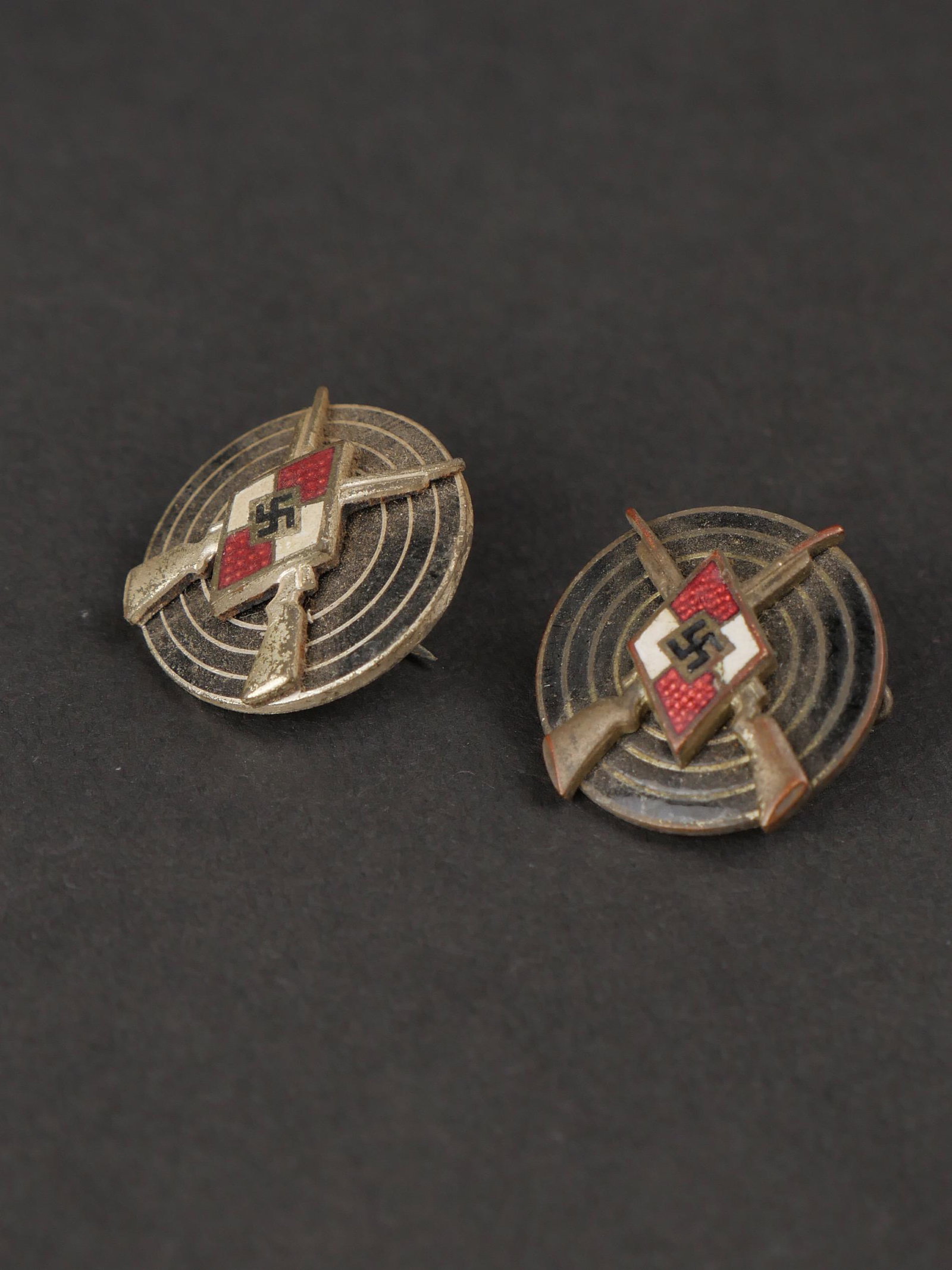Insignes de tir HJ. HJ shooting badges.: Insignes de tir Hiterjugend. Comprenant un insigne en metal peint , couleur argent, attache incomplete, fabrication RZM M1/77, correspondant au fabricant Foersteret Barth Pforzheim. Un insigne de tir 