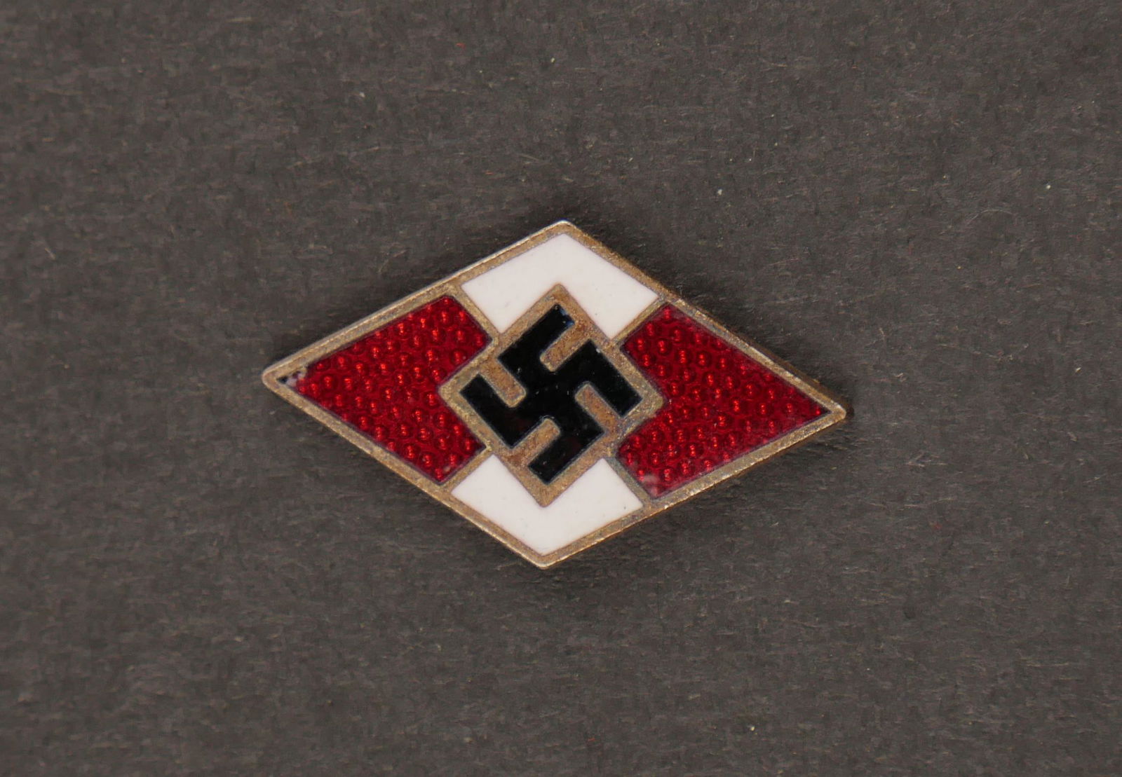 Insigne de dague HJ. HJ dagger badge.: Insigne de dague Hitlerjugend. Bon insigne emaille, sans marquages visibles. A noter une certaine usure et patine de la piece. Etat II+. Badge of dagger Hitlerjugend. Good enameled badge, no visible m