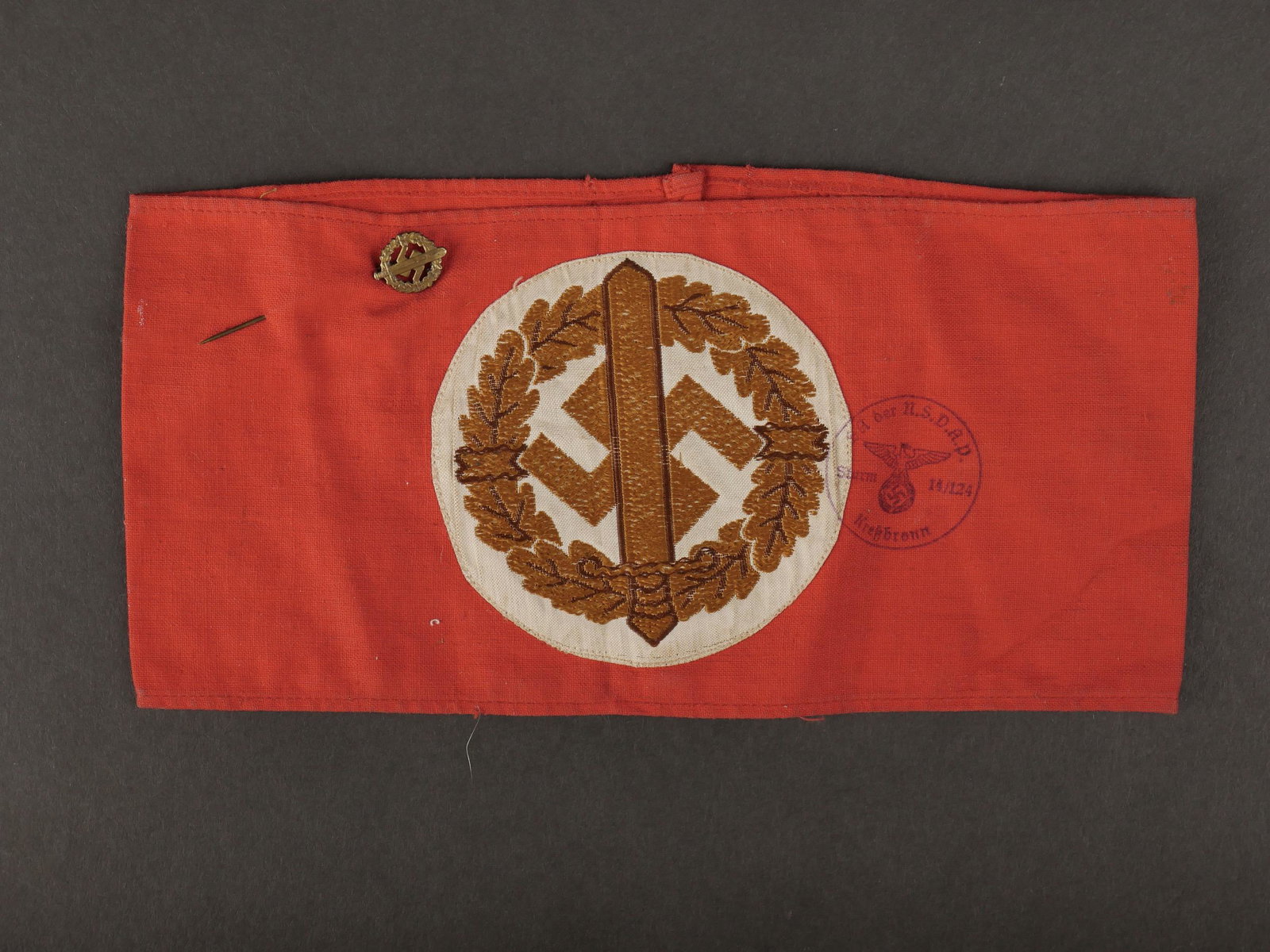Brassard Leistung SA. SA Leistung armband.: Brassard Leistung SA. En tissu coton rouge. Insigne tisse couleur or. Tampon bien marque SA der NSDAP Sturm 14/124, Kressbronn. Reste d etiquette RZM numero 199171, code fabricant 37. On y joint une e