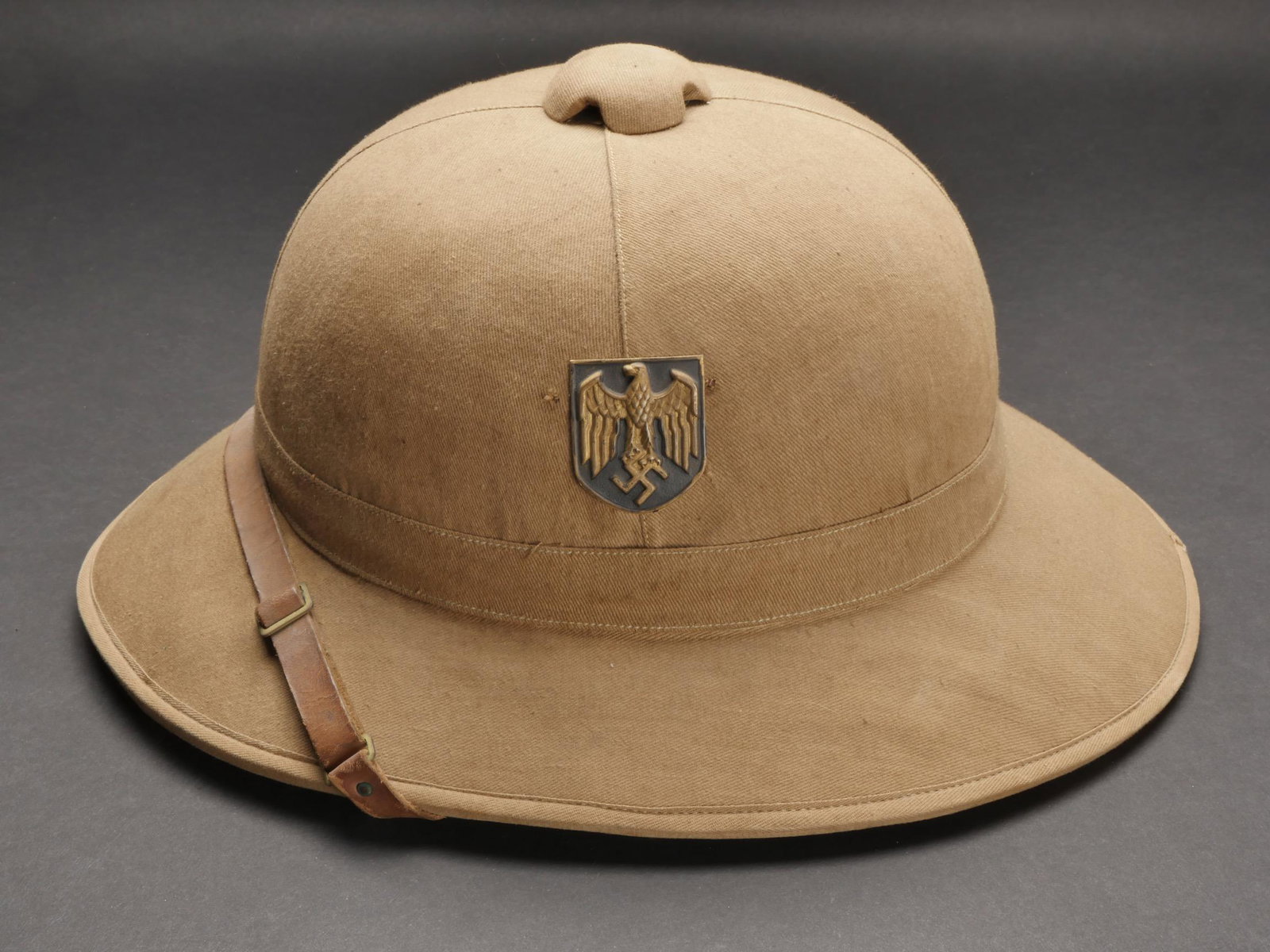 Casque tropical Kriegsmarine. Tropical helmet Kriegsmarine.: Casque tropical Kriegsmarine. En toile beige. Insigne Kriegsmarine dore et couleur nationales. Jugulaire en cuir marron. Les insigne n ont pas ete demontes afin de verifier les attaches. Interieur dou