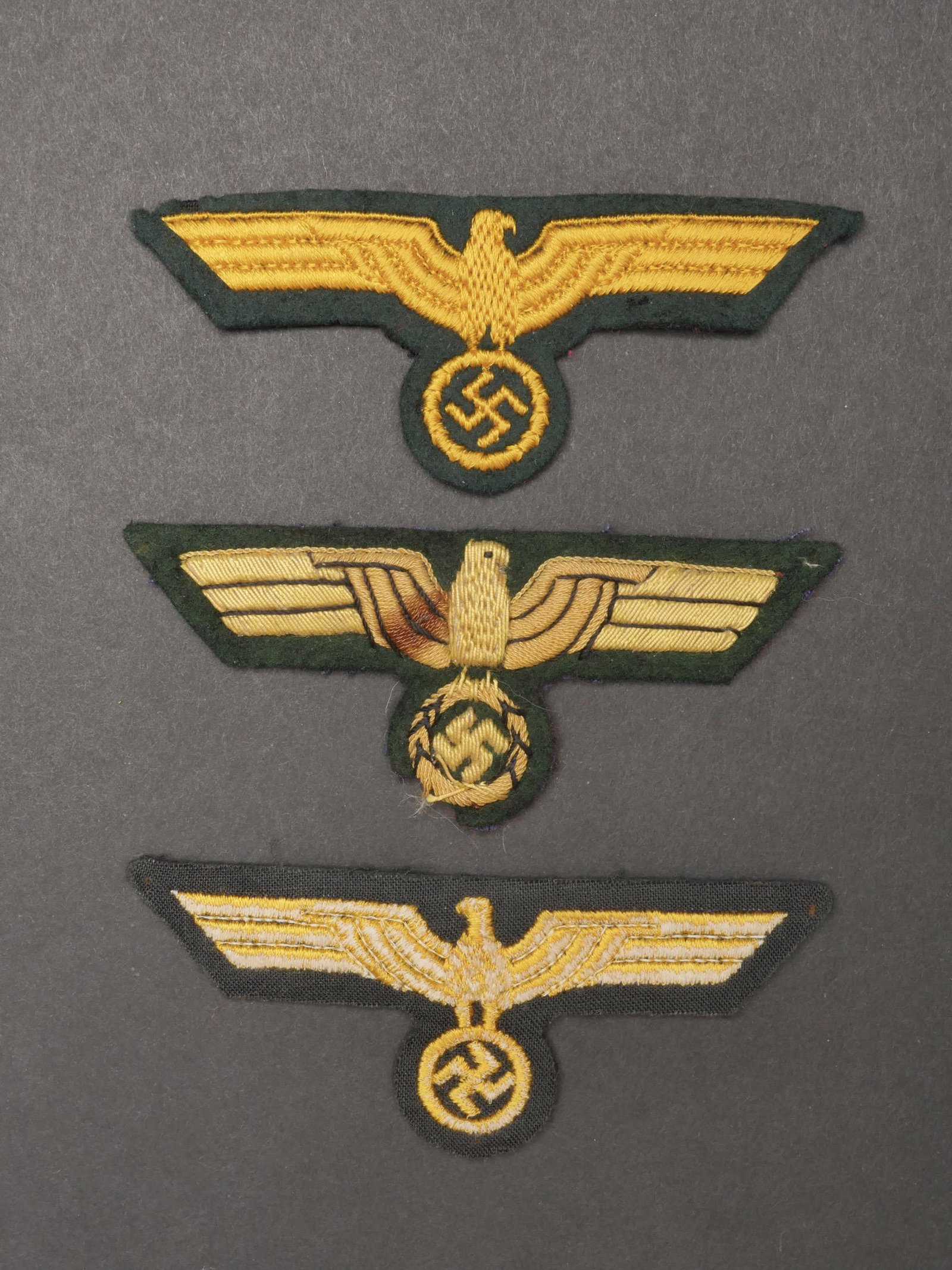 Aigles de poitrine artillerie cotiere. Eagles of chest coastal artillery.: Aigles de poitrine artillerie cotiere. Comprenant un aigle brode jaune sur fond vert fonce, jamais monte. Un aigle de poitrine brode jaune sur fond vert fonce, jamais monte. Un aigle de poitrine en ep