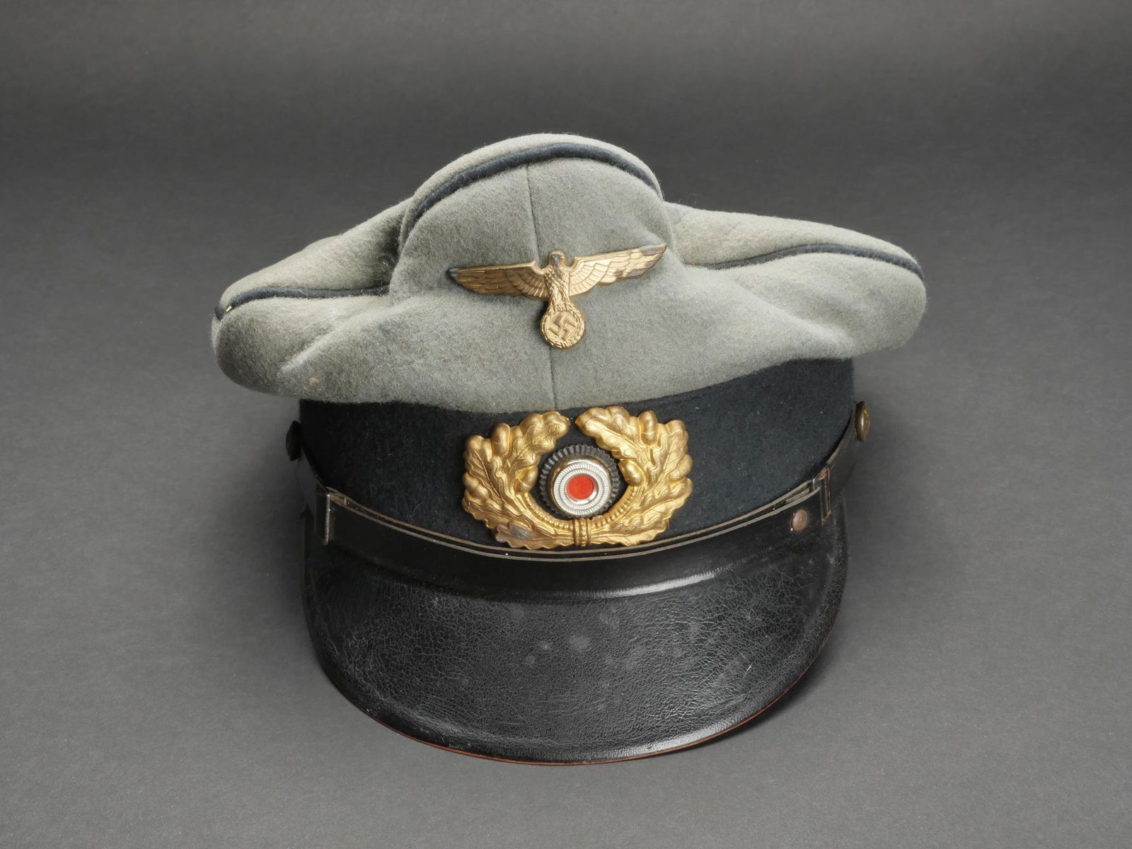Casquette artillerie cotiere. Coastal artillery cap.: Casquette de l artillerie cotiere. En drap Feldgrau, double lisere vert de l artillerie cotiere. Bandeau en drap vert fonce. Insignes metalliques dores. Les insignes n ont pas ete demontes afin de ver