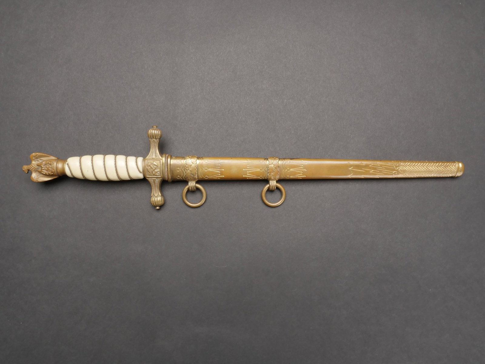 Dague Kriegsmarine. Kriegsmarine dagger.: Dague d officier de la Kriegsmarine. Toutes les garnitures sont en metal dore. Poignee en celluloid blanche, filigrane or. Bouton poussoir fonctionnel. Belle lame gravee d une ancre de marine. Fabrica