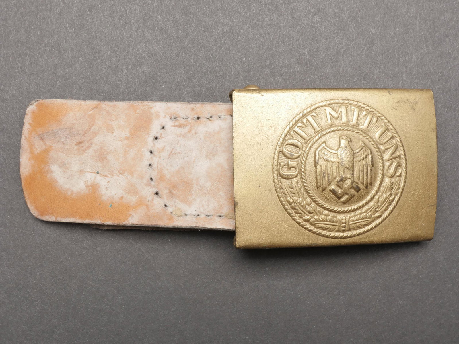 Boucle de ceinturon Kriegsmarine. Kriegsmarine belt buckle.: Boucle de ceinturon Kriegsmarine. En metal lisse. Couleur or a 90. Importante trace de colle au dos de l insigne. Sans marquages fabricant visible. Patte en cuir complete, mais decousue. Fabrication L
