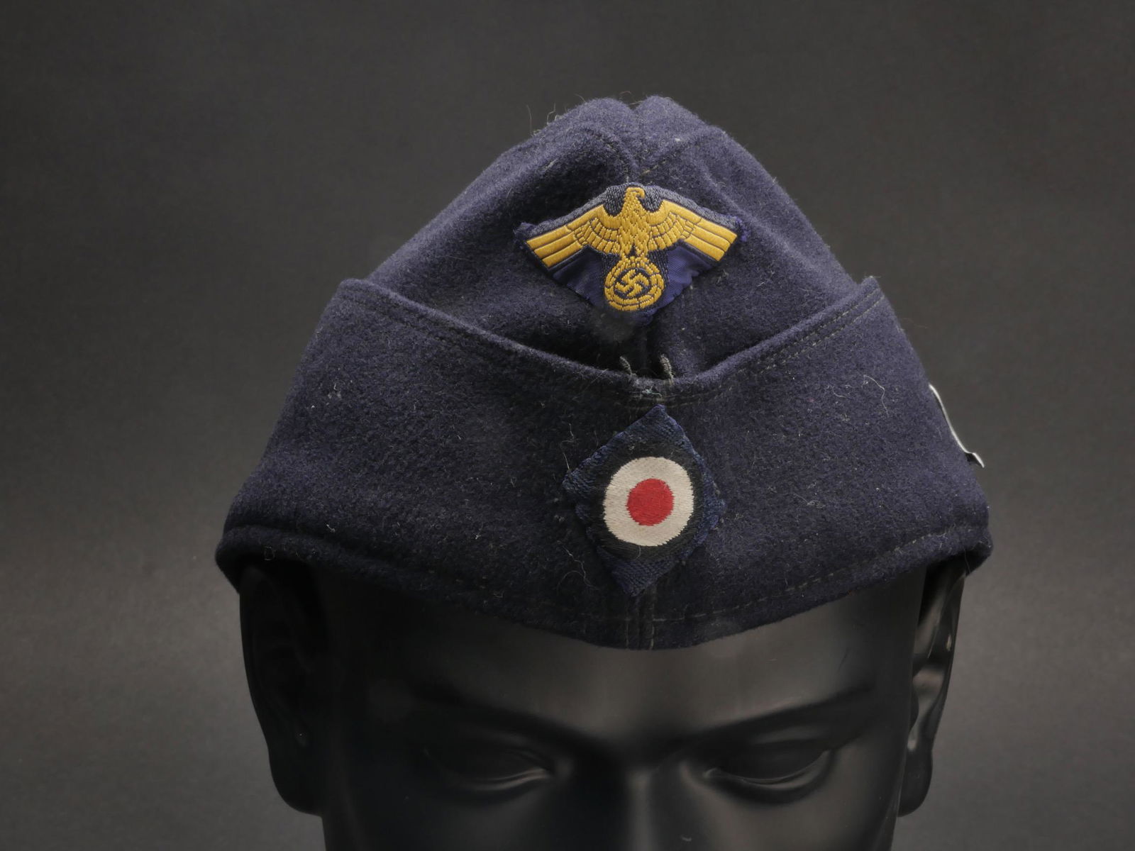 Calot Kriegsmarine. Kriegsmarine cap.: Calot Kriegsmarine. En drap bleu marine. Aigle Kriegsmarine Bevo, monte main. Cocarde Bevo montee main. Edelweiss metallique cousu sur le cote du calot. Interieur double en tissu noir. Marquages Johan