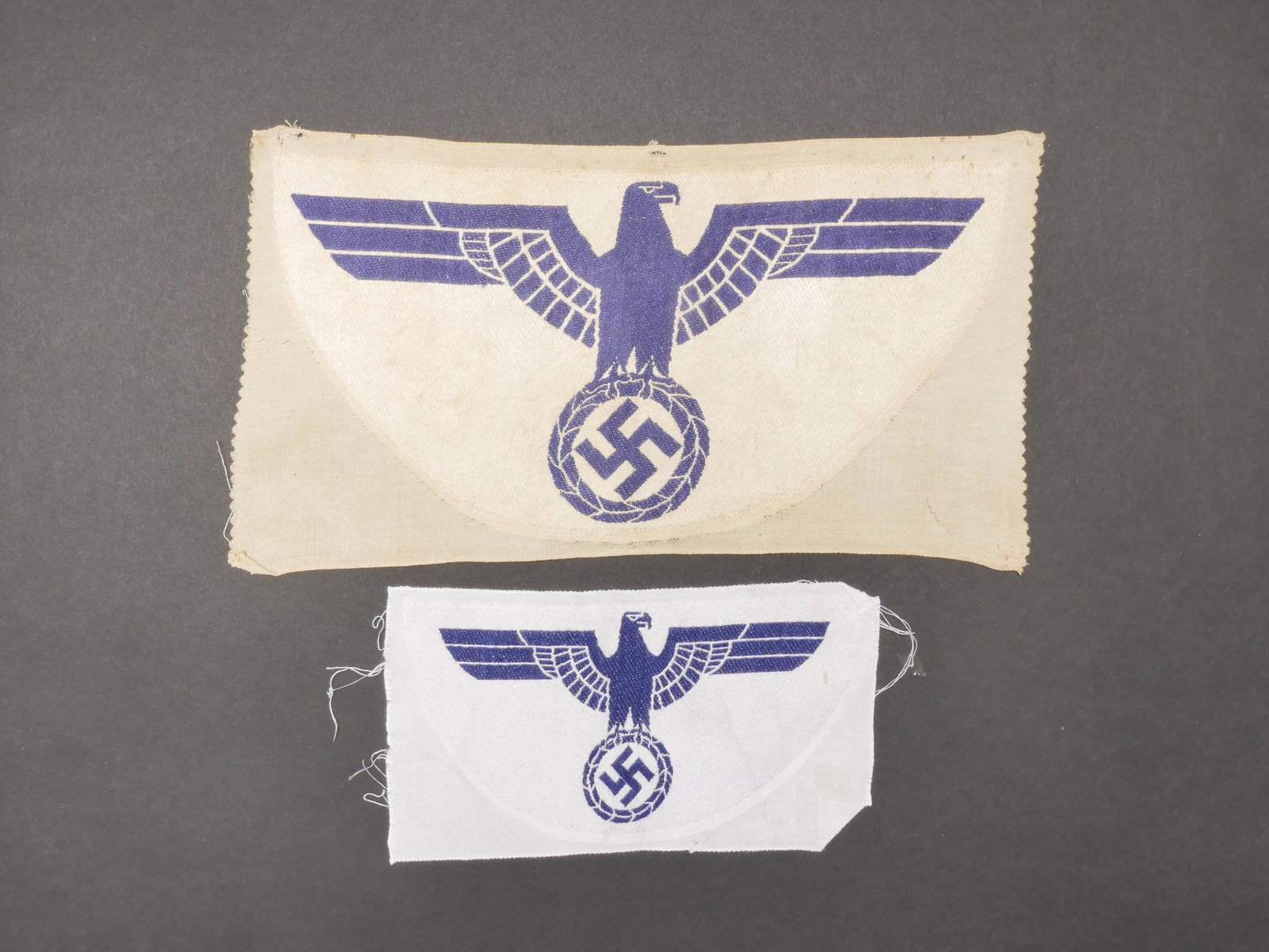 Insignes de maillots de sport Kriegsmarine. Kriegsmarine sports shirt badges.: Insignes de maillots de sport Kriegsmarine. Comprenant un grand modele d insigne de maillot de sport sur fond blanc, jamais monte. Un petit modele d insigne sur fond blanc, jamais monte. A noter une c