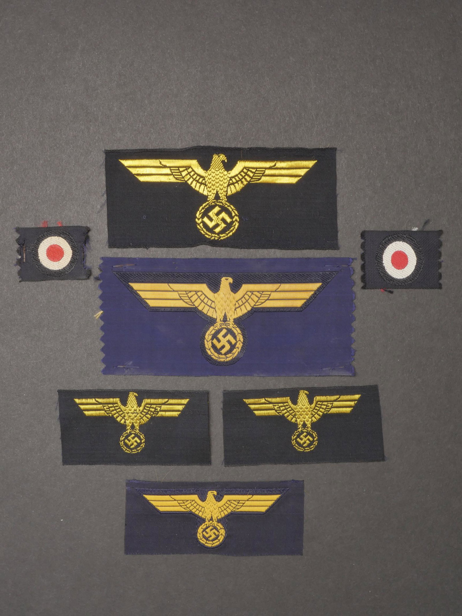 Insignes Kriegsmarine. Kriegsmarine insignia.: Insignes Kriegsmarine. Comprenant un aigle de calot Bevo, jamais monte. Un aigle de poitrine Bevo, jamais monte. Une cocarde Bevo, jamais monte. Un aigle de calot Bevo, jamais monte. Un aigle de poitr