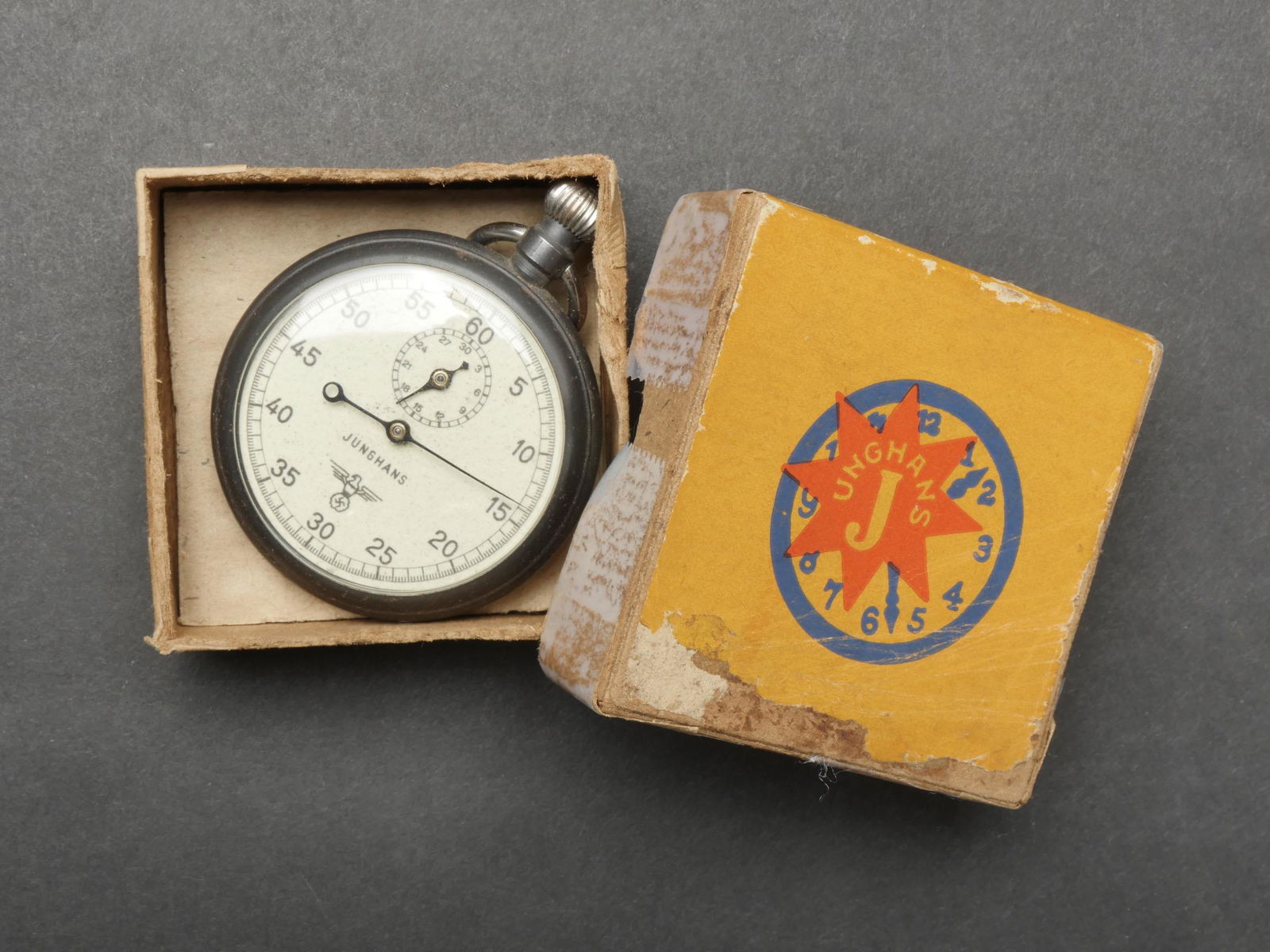 Chronometre KM. KM stopwatch.: Chronometre Kriegsmarine. Belle boite en carton, reparee avec du scotch sur les cotes. Marquages Junghans. Chronometre en metal, les aiguilles sont completes. Verre en parfait etat, fabrication Jungha