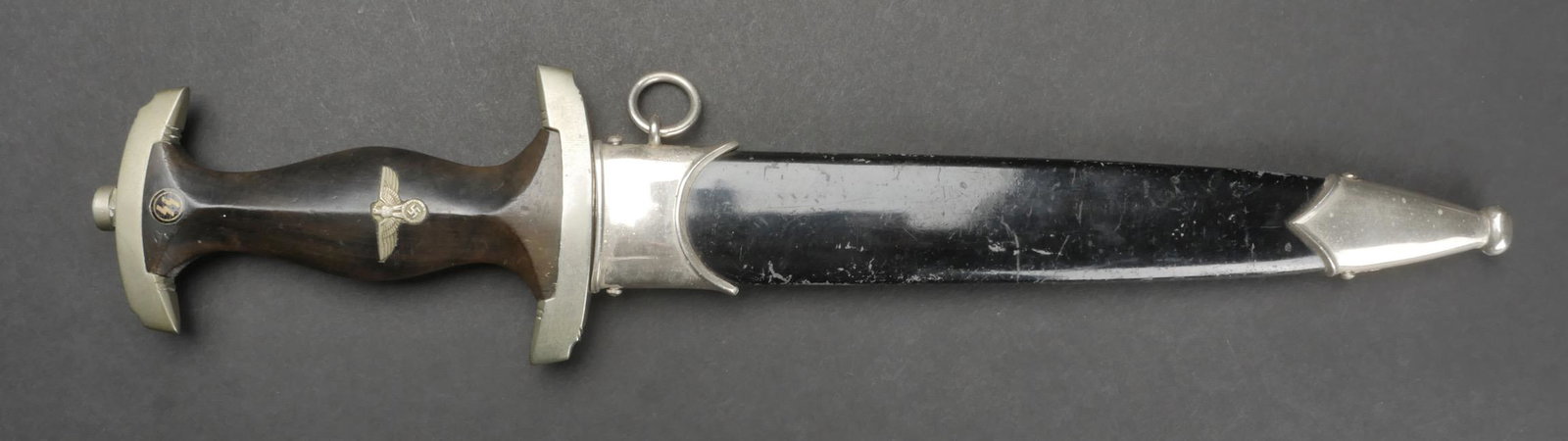 Dague SS. SS Dagger.: Dague SS. Modele 33. Toutes les garnitures sont en metal. Poignee en bois noir, fortement use et partiellement decolore, couleur tirant sur le marron. Pastille SS et aigle montes d origine. Belle lame