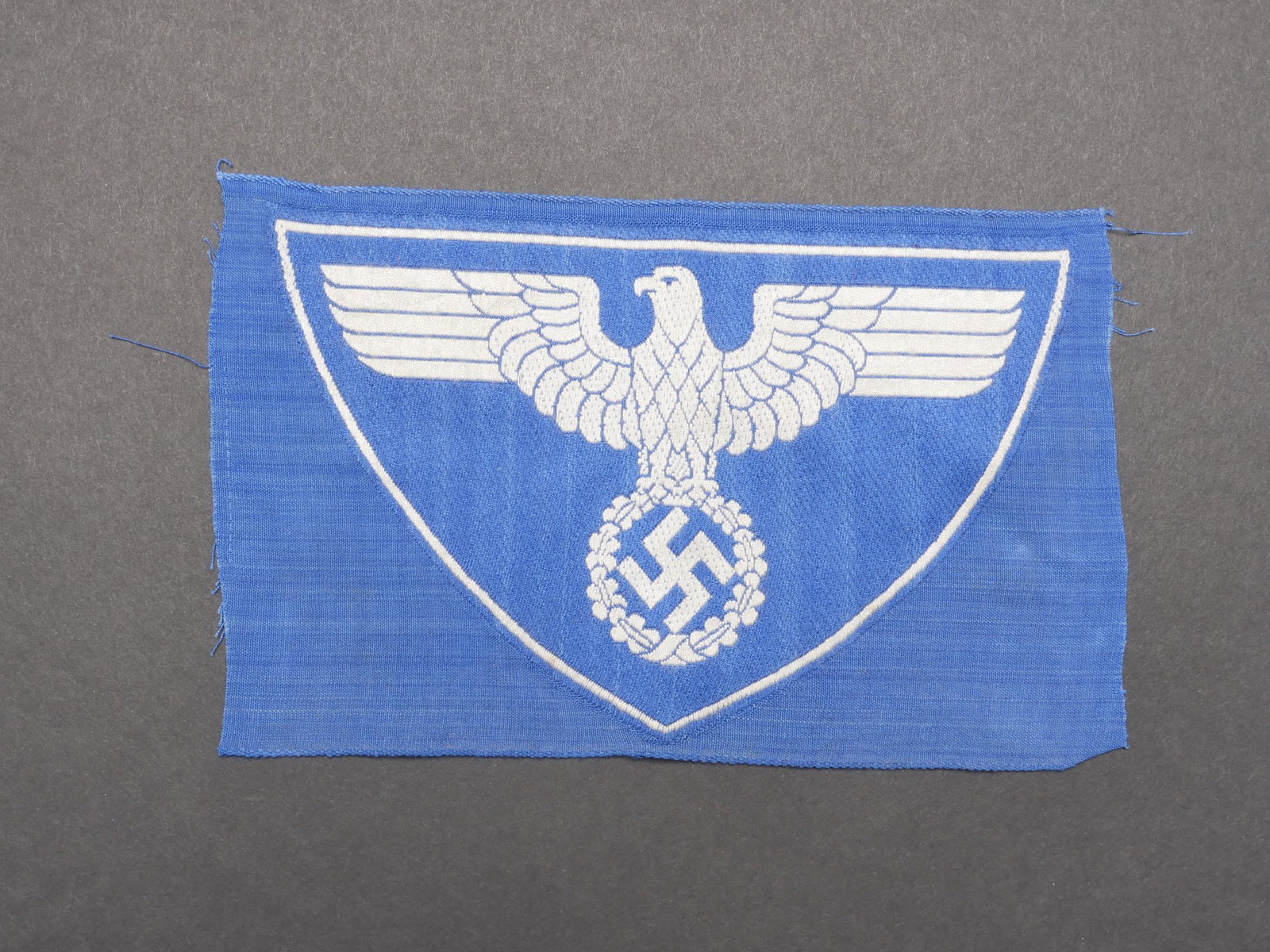 Insigne de maillot de sport. Sports jersey badge.: Insigne de maillot de sport. Modele tisse sur fond bleu roi. Jamais monte. Sans marquages visibles. A noter une certaine usure et patine de la piece. Etat I-. Badge of sports jersey. Woven pattern on 