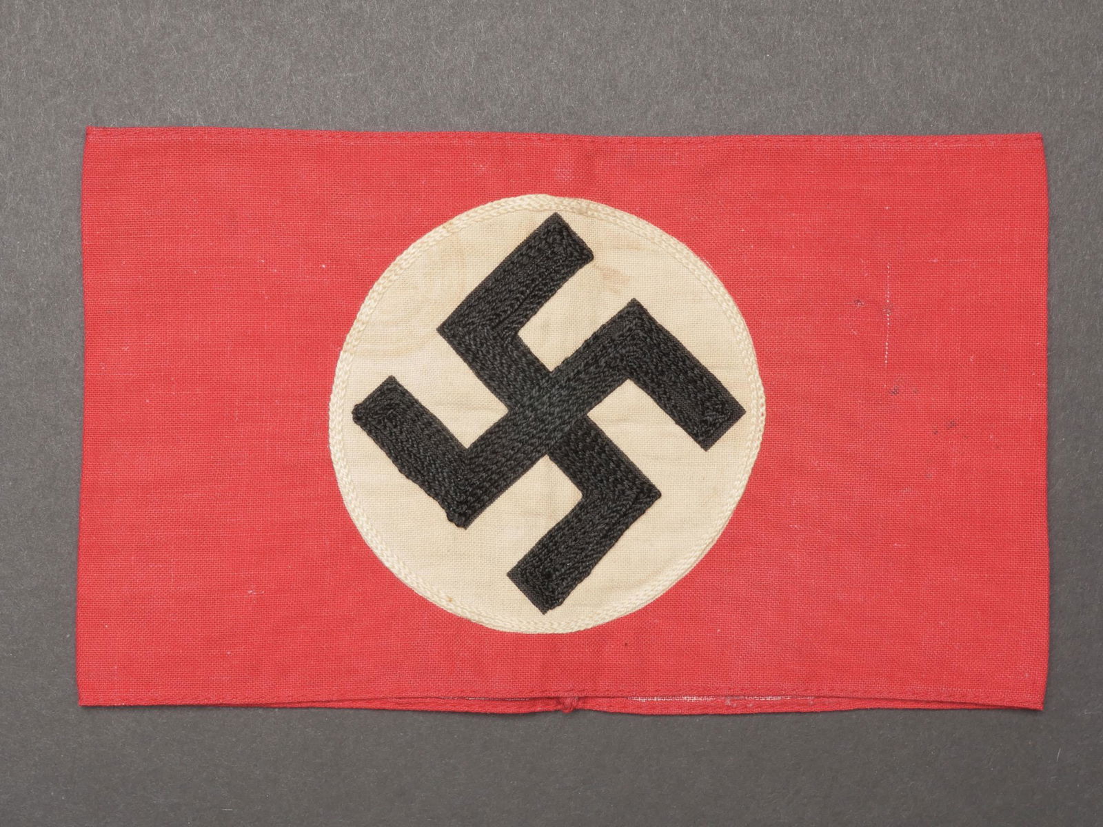 Brassard allemand. German armband.: Brassard allemand. En tissu coton rouge. Insigne brode et rapporte. Sans marquage fabricant visible. A noter une certaine usure et patine de la piece, ainsi que quelques taches. Etat II+. German armba