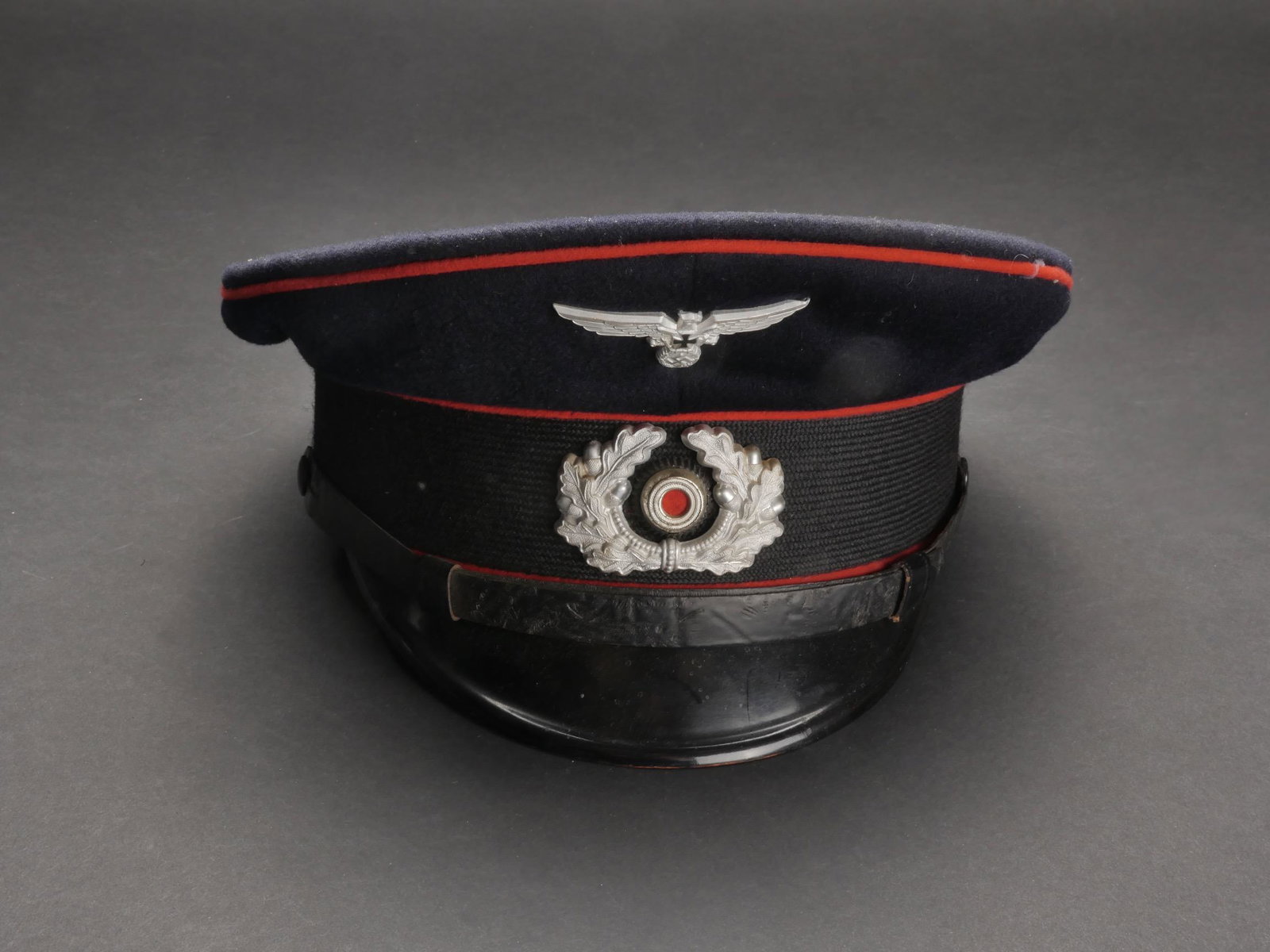 Casquette ancien combattant. Veteran s cap.: Casquette des anciens combattants de l artillerie. En drap bleu marine. Triple lisere rouge de l artillerie. Insignes metalliques. Les insignes n ont pas ete demontes afin de verifier les attaches. Fa