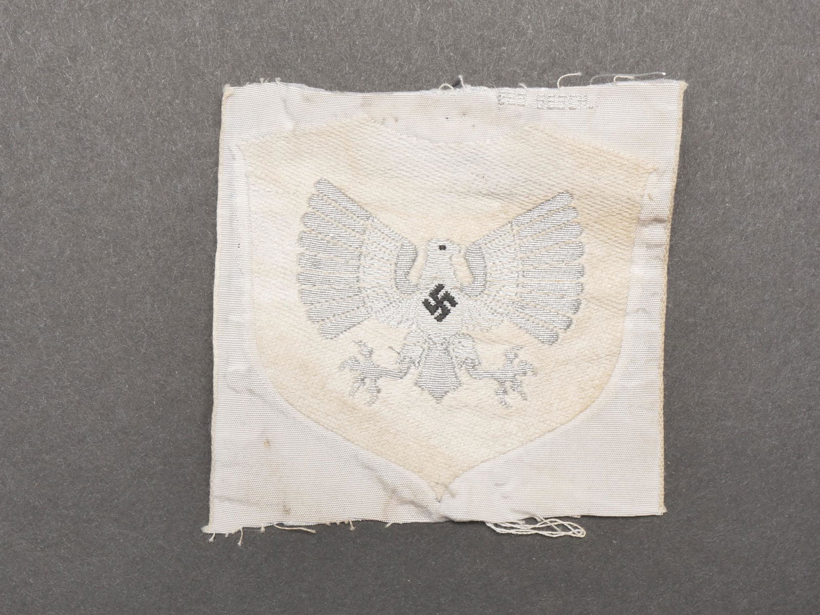 Insigne de Gruppenfuhrerin BDM. BDM Insignia.: Insigne de Gruppenfuhrerin BDM. Modele tisse argent sur fond blanc. Jamais monte. A noter une certaine usure et patine de la piece, ainsi que quelques manques et taches. Etat II+. Badge of Gruppenfuhr