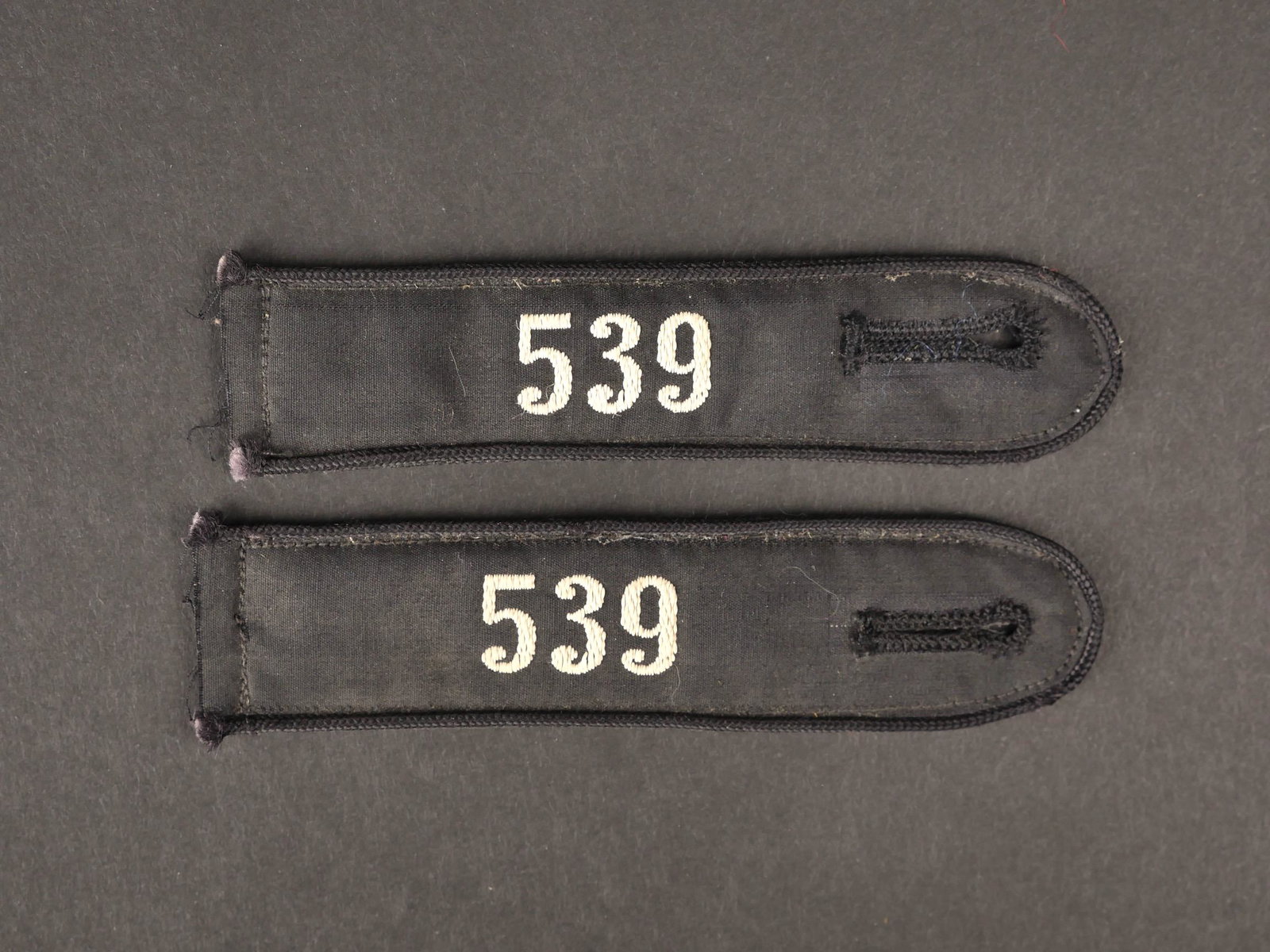 Pattes d epaule DJ. DJ shoulder straps.: Pattes d epaule DJ. Bann 539, correspondant au Salzburg-Land. Paire homogene en tissu noir, chiffre 539 brode en fils blanc. Jamais portees. Etiquette RZM numero 183470 et 176171, code fabricant 97. A