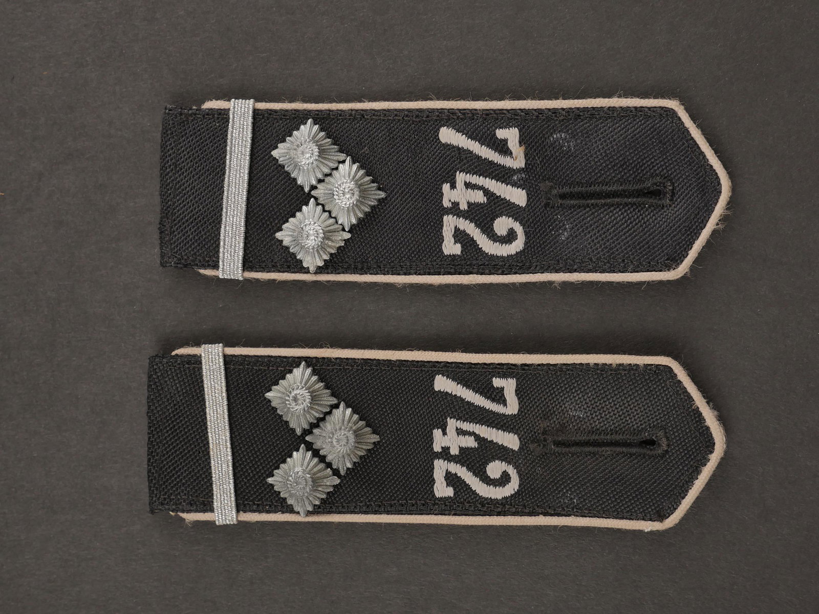 Pattes d epaule HJ. Hj shoulder straps.: Pattes d epaule d Obergefolgschaftsfuhrer. Bann 742 Ribeauville Alsace. Paire homogene en tissu noir, lisere blanc. Lettrage 742 brode en fil blanc. Jamais monte. Grade d Obergefolgschaftfuhrer. Etiqu