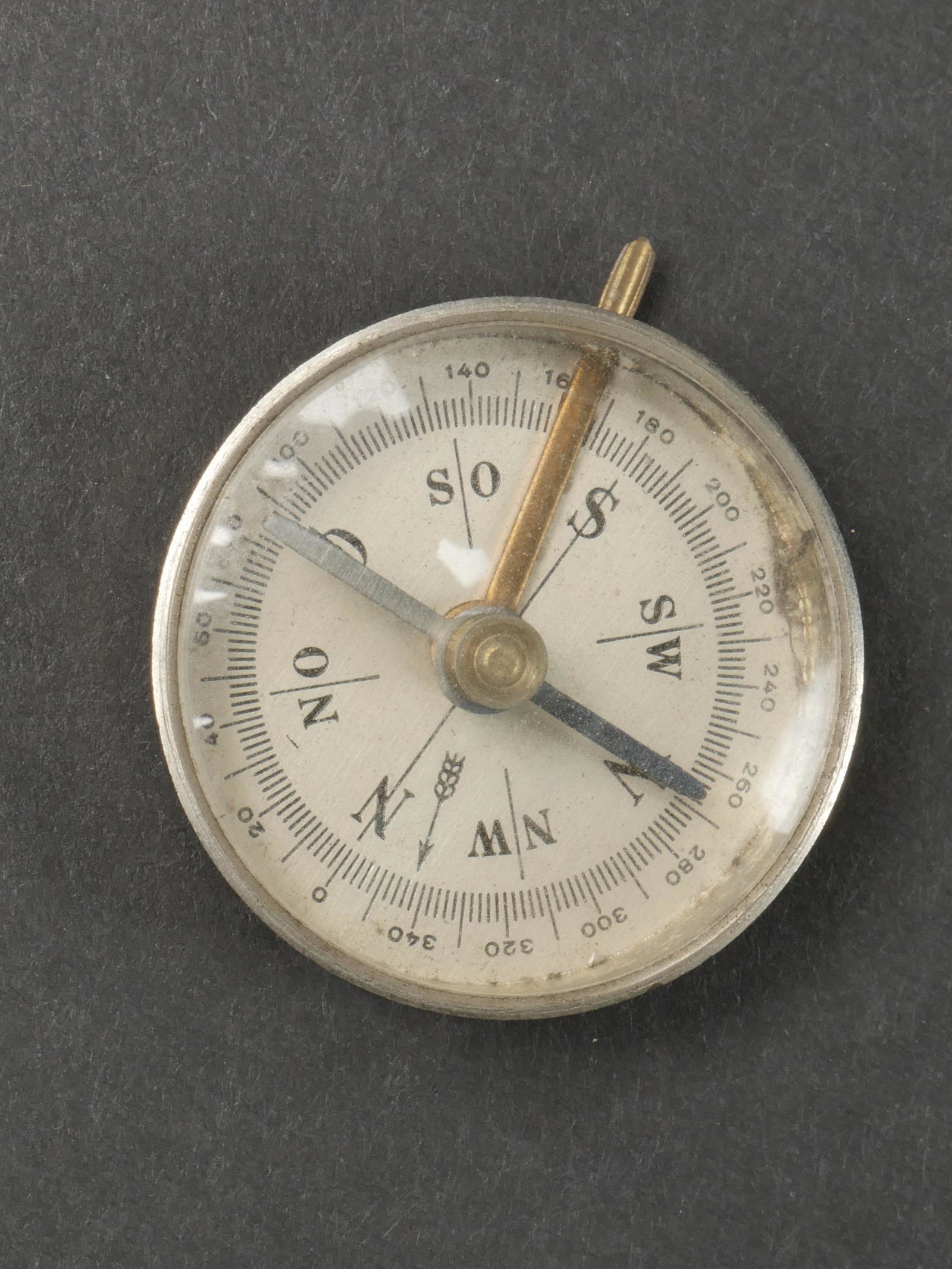 Boussole HJ. Compass HJ.: Boussole Hitlerjugend. Petite boussole en metal, fonctionnelle. Verre en parfait etat. Au dos se trouve l insigne de la Hitlerjugend, et le marquage HCO. A noter une certaine usure et patine de la pie
