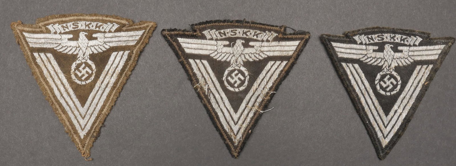 insignes de manche NSKK. NSKK sleeves insignia.: Insignes de manche NSKK. Comprenant un insigne de manche tisse sur un fond beige, etiquette RZM numero 211320, code fabricant RZM M4/374. Un chevron de manche en cannetille argent sur fond beige, rest