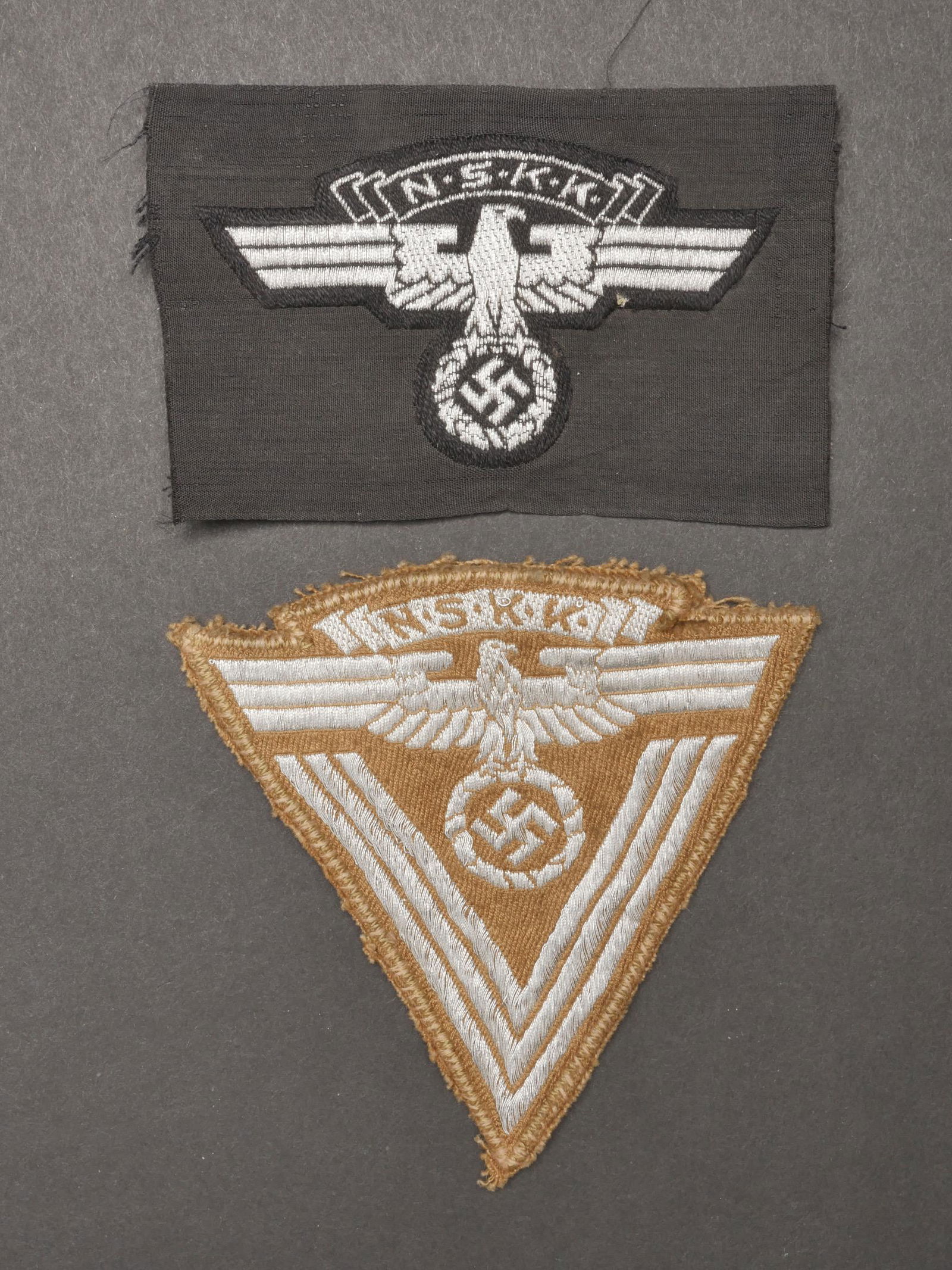Insignes NSKK. NSKK insignia.: Insignes NSKK. Comprenant un grade de manche NSKK, tisse sur fond beige. Un insigne NSKK tisse Bevo sur fond noir, jamais monte. A noter une certaine usure et patine des pieces. Etat II+. NSKK Insigni