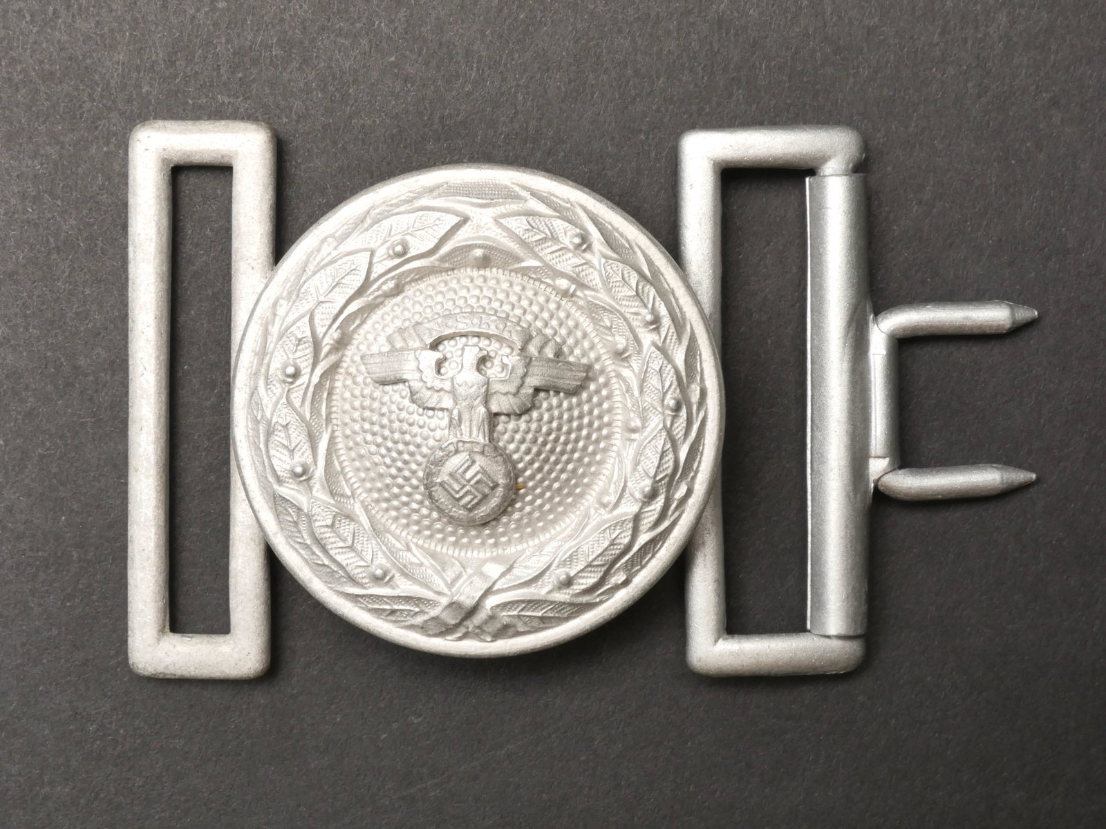 Boucle de ceinturon officier NSKK. NSKK officer belt buckle.: Boucle de ceinturon d officier NSKK. Boucle pour officier en aluminium, bel aigle NSKK, la partie avec ardillon est presente. Sans marquages visibles. A noter une certaine usure et patine de la piece.