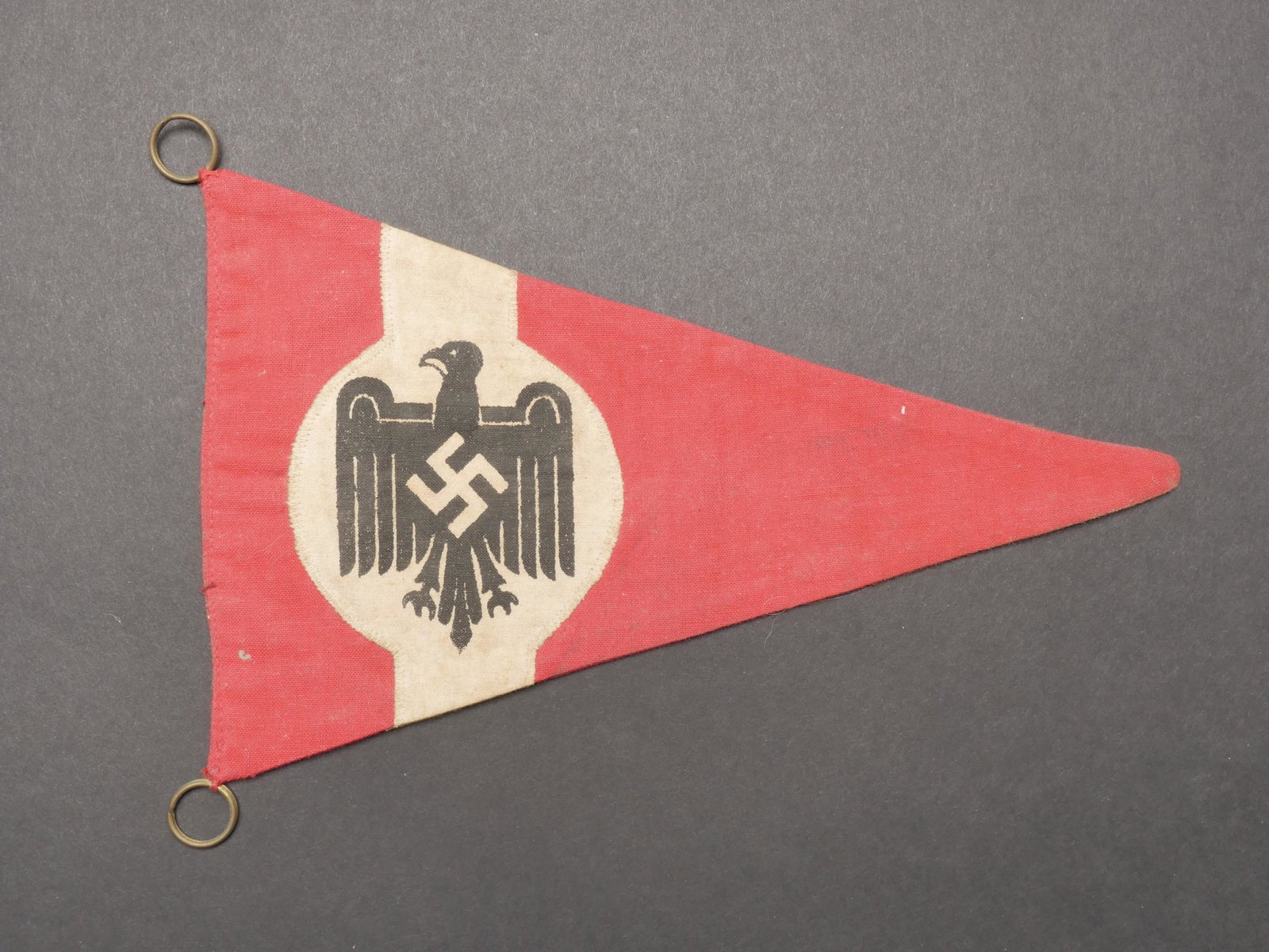 Fanion NSRL. NSRL pennant.: Fanion NSRL. En tissu rouge. Insigne imprime et rapporte. Deux Å“illets presents. Biface. Dimensions 14,5 x 23,5 cm. A noter une certaine usure et patine de la piece, ainsi que quelques taches. Eta