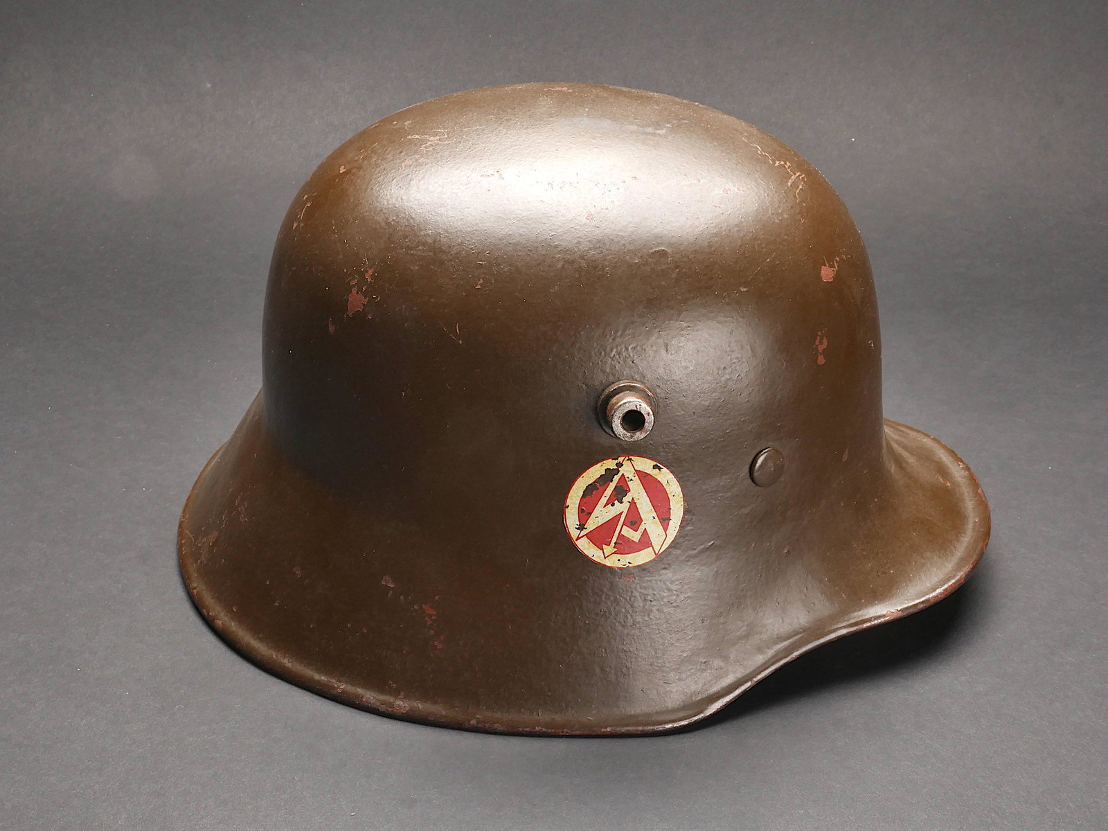 Casque de la SA. SA helmet: Casque de la SA. Coque de casque du modele 16, fabrication ET 64. Peinture marron a 80%. Aigle de la SA a 80%. Insigne de la SA a 70%. Coiffe en cuir complete. Cordon de serrage posterieur. Un coussin