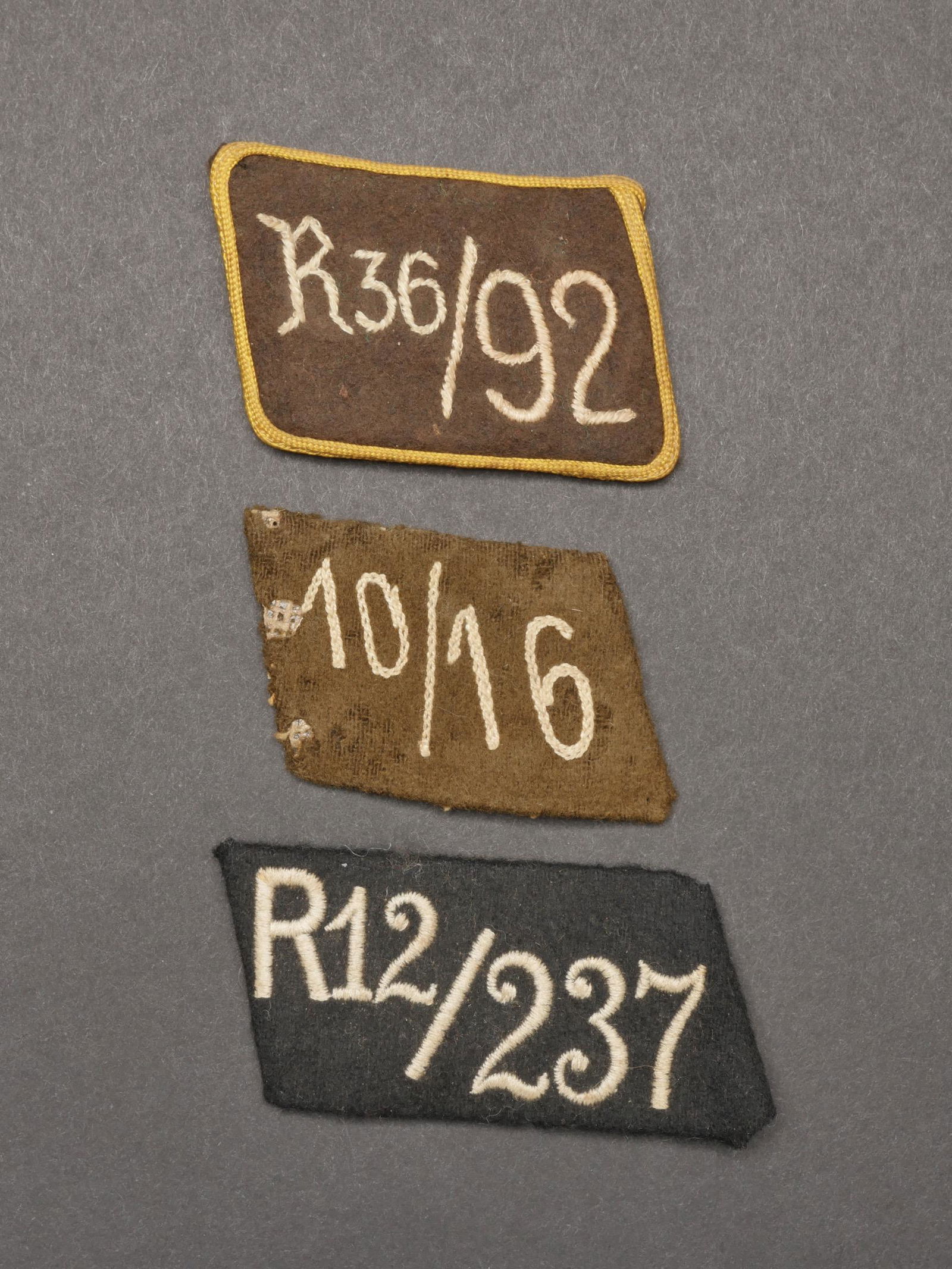 Pattes de col SA. SA collar tabs.: Pattes de col SA. Comprenant une patte de col en drap noir, brode R12/237. Une patte de col en drap marron, Donau, Alpland, lisere jaune faisant le tour de la patte d epaule, broderie R36/92. Une patt