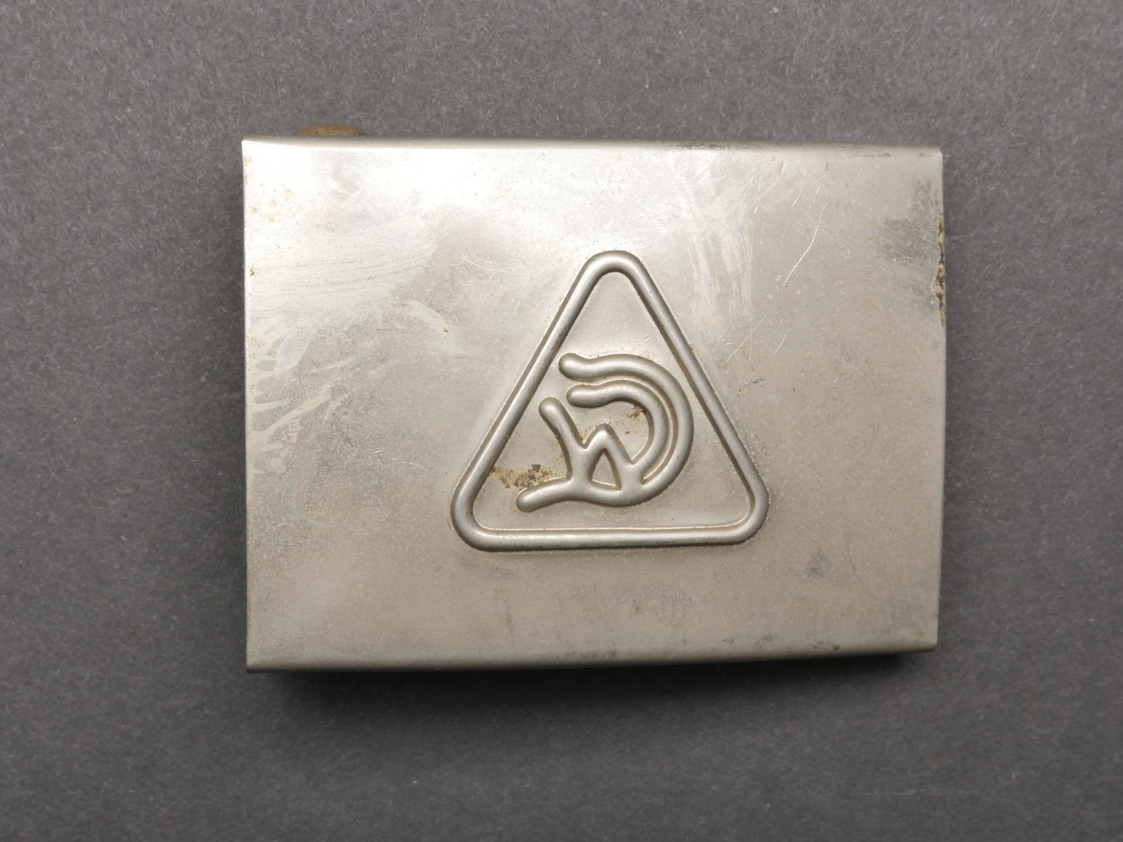 Boucle de ceinturon Draeger Werk. Draeger Werk belt buckle.: Boucle de ceinturon Draeger Werk. En metal, insigne en relief. Boucle a deux ardillons presente. Sans marquages visibles. A noter une certaine usure et patine de la piece. Etat II+. Buckle of belt Dra