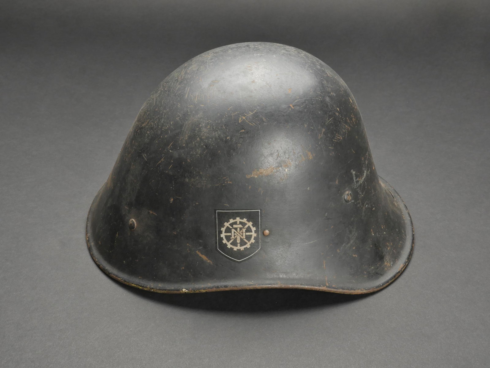 Casque du Teno Hollandais. Dutch Teno helmet.: Casque du Teno. Coque de casque en metal. Modele Hollandais. Peinture noire a 80%. Insigne du Teno a 90%, couleurs nationales hollandaises a 90%. Interieur presentant une certaine oxydation. Numero de