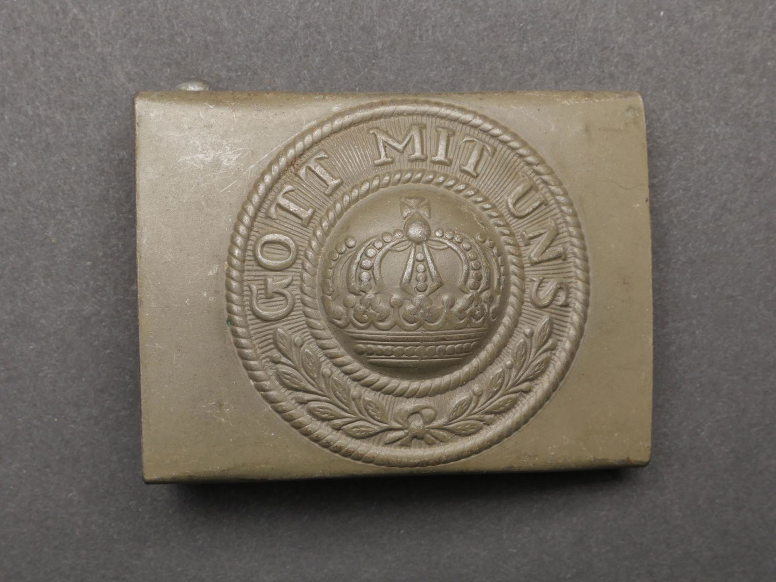 Boucle de ceinturon WWI. WWI belt buckle.: Boucle de ceinturon WWI. En metal, peinture Feldgrau a 80%. Boucle a deux ardillons presents. Sans marquages visibles. A noter une certaine usure et patine de la piece. Etat II+. WWI belt buckle. Meta