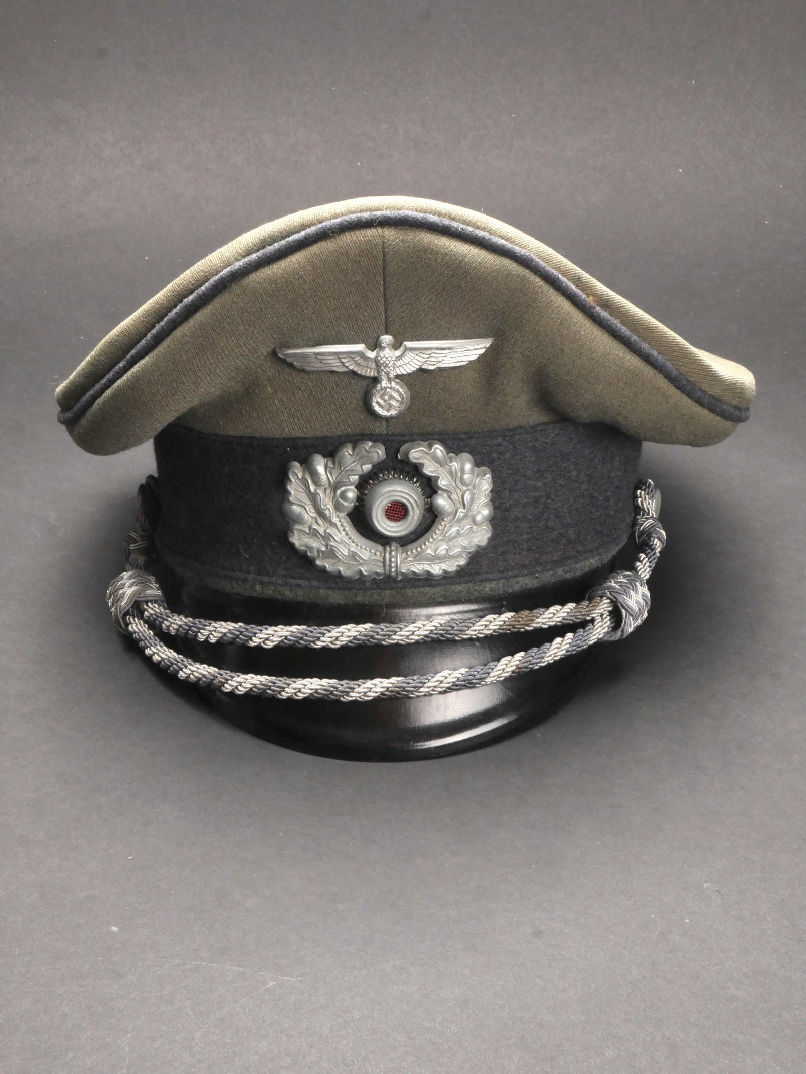 Casquette de Sonderfuhrer. Sonderfuhrer Cap.: Casquette de Sonderfuhrer. En gabardine Feldgrau. Triple lisere gris. Bandeau en drap gris. Insignes metalliques. Les insignes n ont pas ete demontes afin de verifier les attaches. Fausse jugulaire d 