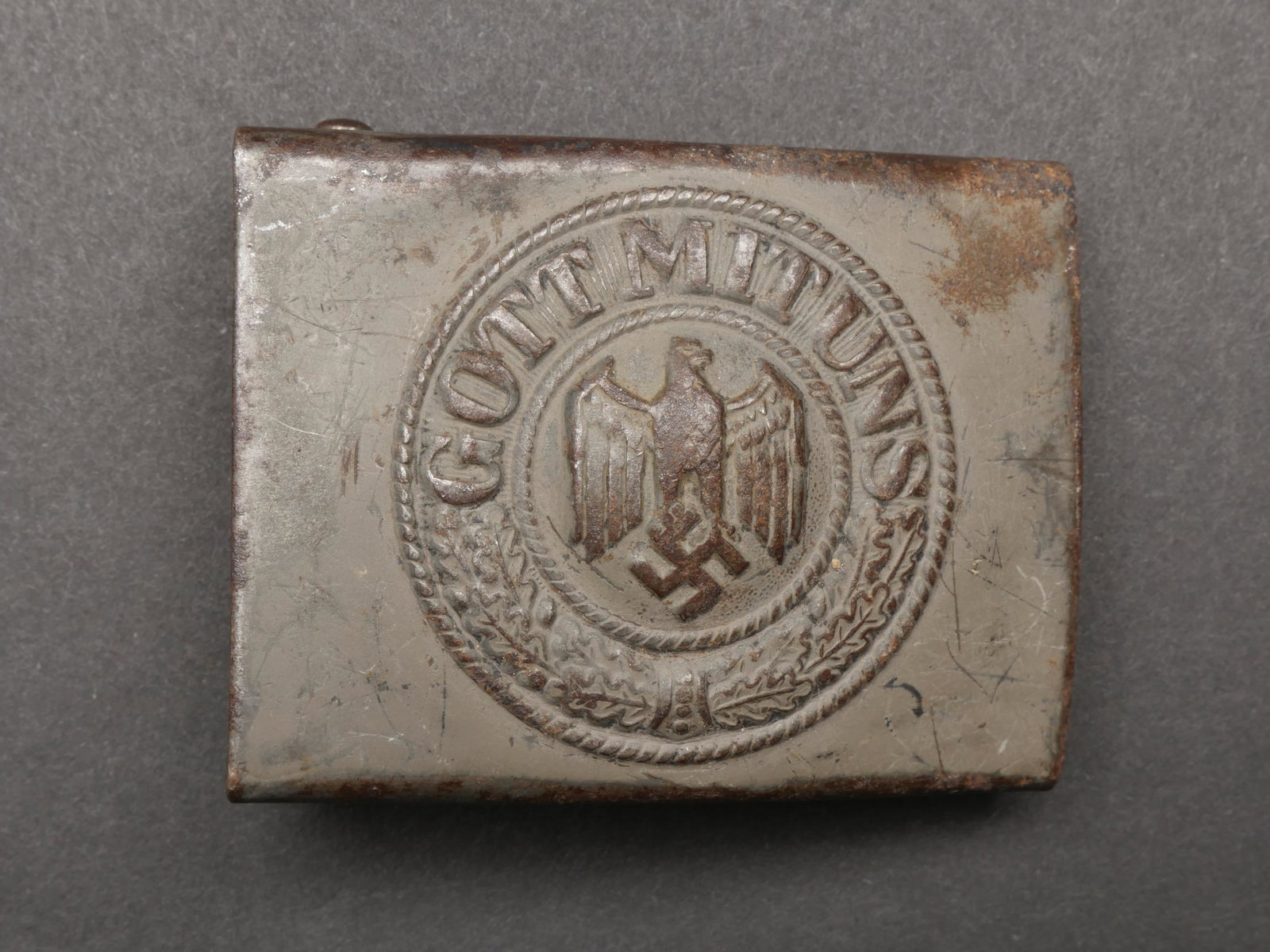 Boucle de ceinturon Heer. German belt buckle.: Boucle de ceinturon Heer. En metal. Peinture Feldgrau a 60%. Insigne en relief. Boucle a double ardillon presente. Sans marquages visibles. A noter une certaine usure et patine de la piece. Etat II+. 