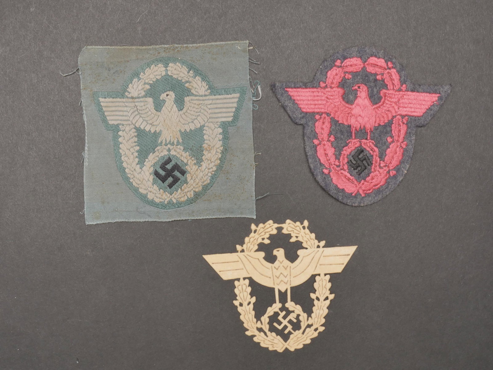 Insignes Polizei. Police insignia.: Insignes Polizei. Comprenant un insigne de manche, modele Bevo, jamais monte. Un insigne Polizei de manche, modele en carton ajoure. Un insigne de manche FeuerWehr, brode sur fond gris/bleu. A noter u