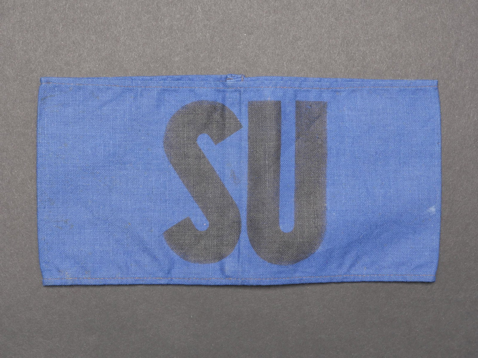 Brassard des prisonniers de guerre sovietique. Armband of the Soviet prisoners of war.: Brassard des prisonniers de guerre sovietique. En tissu coton bleu. Marquage imprime SU en noir. Sans marquages visibles. A noter une certaine usure et patine de la piece, ainsi que quelques t aches. 