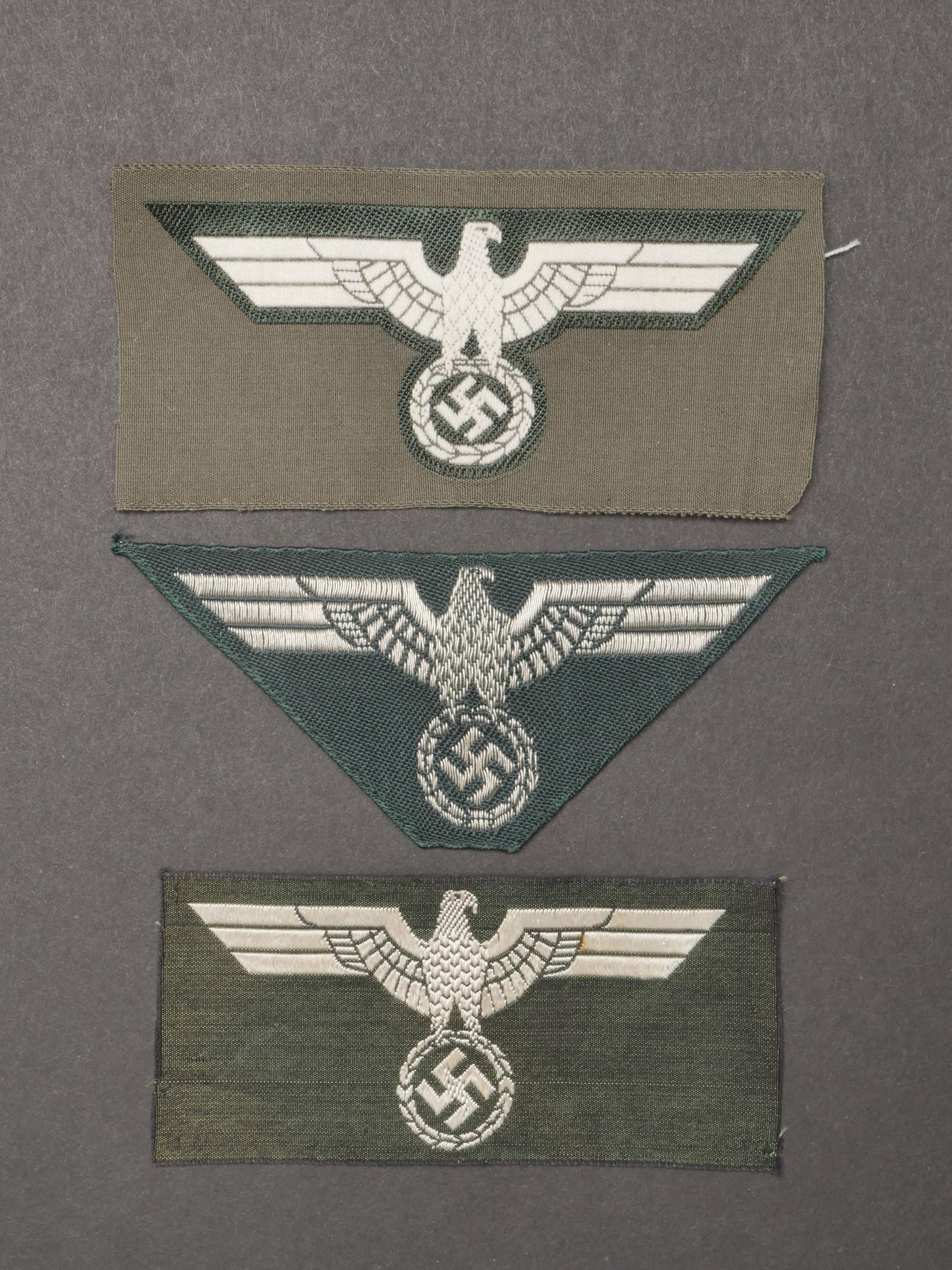 Aigles de poitrine Heer. Heer chest eagles.: Aigles de poitrine Heer. Comprenant un aigle de poitrine brode, sur fond vert canard, format triangulaire. Un aigle de poitrine tisse sur fond en tissu Feldgrau, jamais monte. Un aigle de poitrine tis