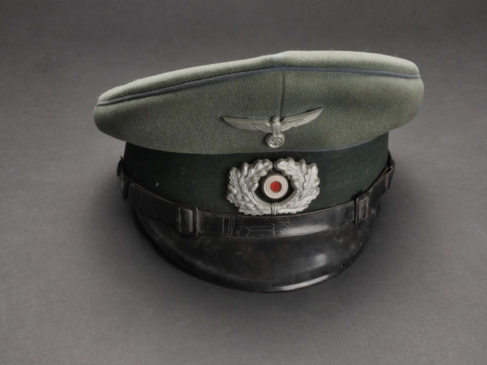 Casquette des transport. German cap: Casquette de sous-officier des transports. En drap Feldgrau. Triple lisere bleu ciel des unites de transport. Bandeau en drap vert fonce. Insignes metalliques. Les insignes n ont pas ete demontes afin