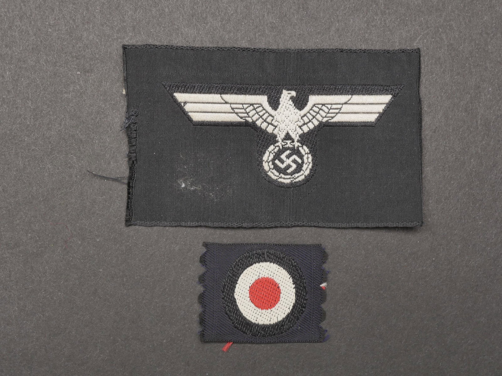 Insignes de calot Panzer. Panzer cap insignia.: Insignes de calot Panzer. Comprenant une cocarde Bevo, jamais monte. Un aigle de calot Bevo, jamais monte ni decoupe. Traces de colle au dos. A noter une certaine usure et patine des pieces. Ensemble 