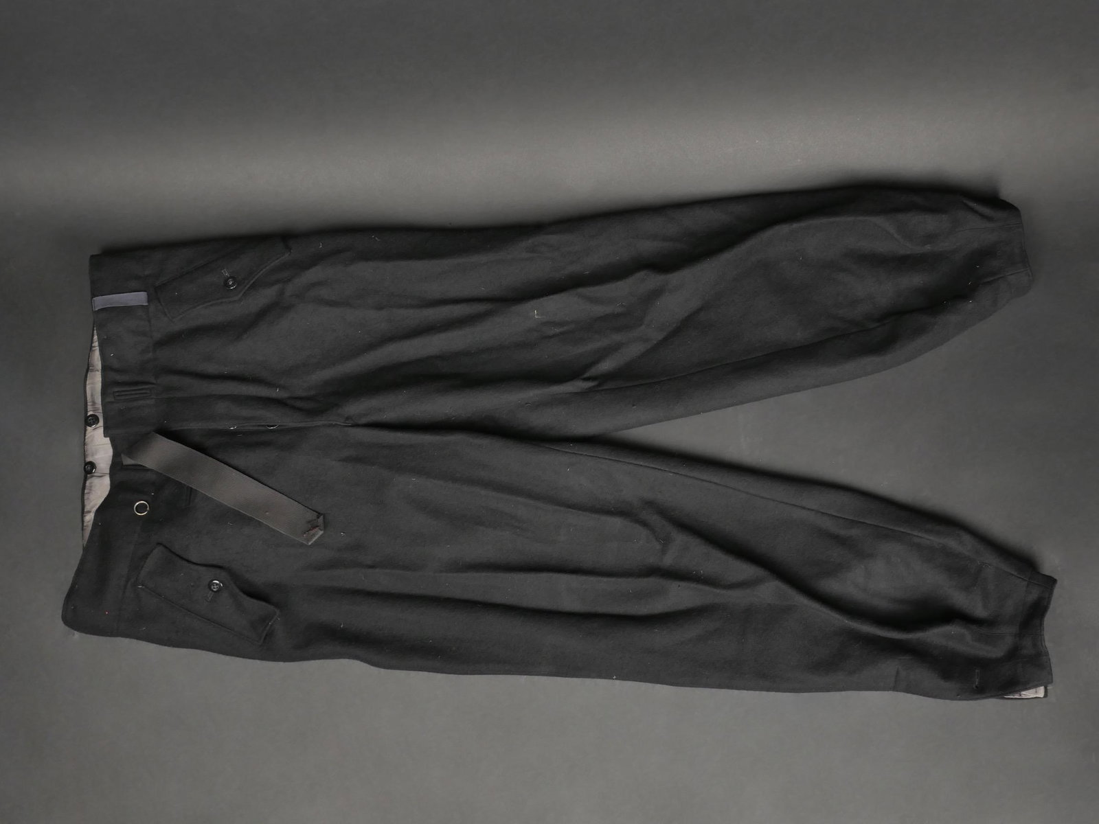 Pantalon Panzer. German panzer pants.: Pantalon Panzer. En epais drap noir. Poches de hanche sous rabat, fermant par un seul bouton. Tous les boutons sont presents. Ceinture en toile noir complete. Bas des jambes double en satinette grise 