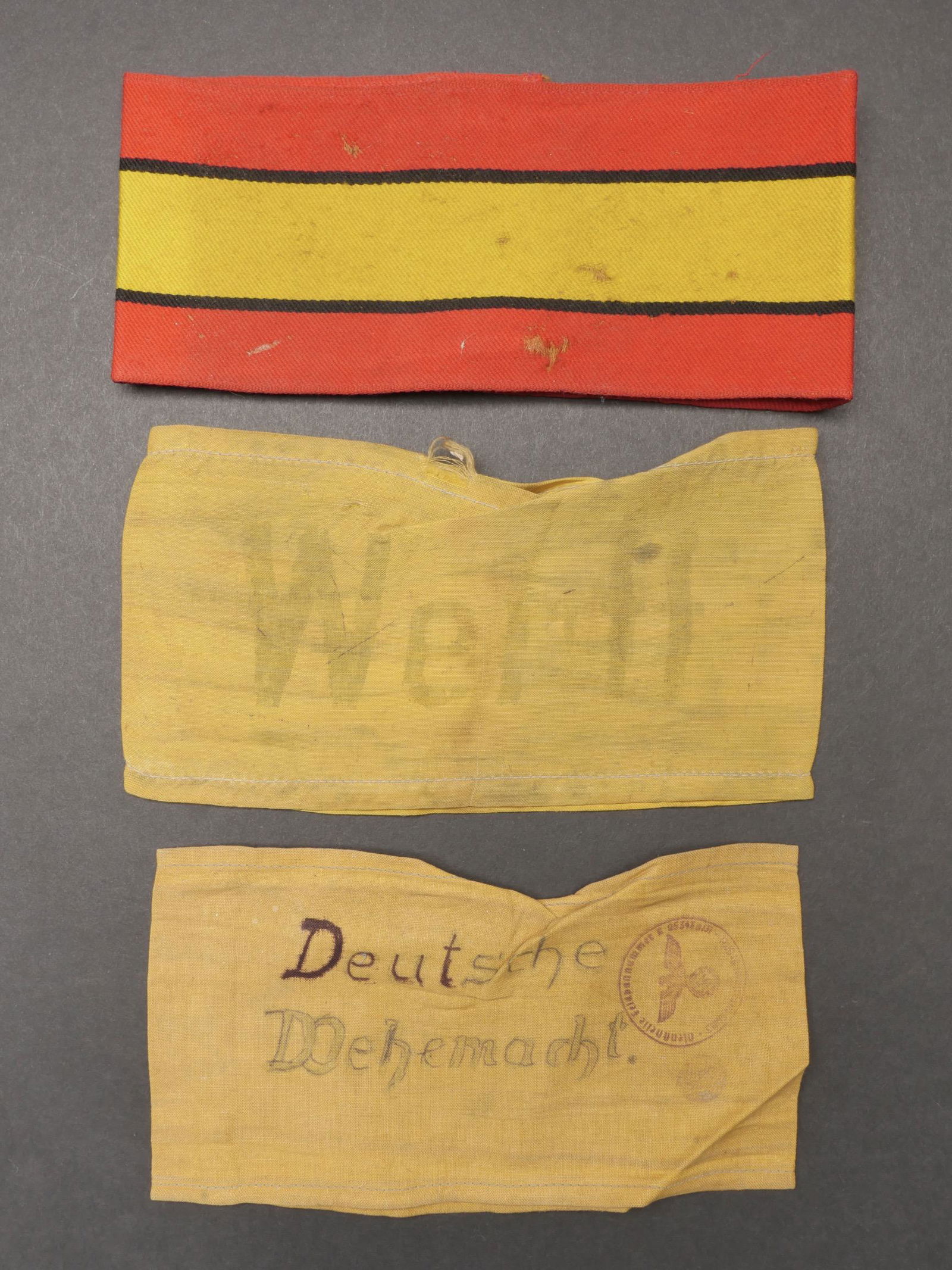 Brassards allemand. German armband.: Brassards allemand. Comprenant un brassard en tissu coton jaune, marque manuellement Deutsche Wehrmacht, tampon present, mais illisible. Un brassard en tissu coton jaune, reste de marquage Werff. Un b