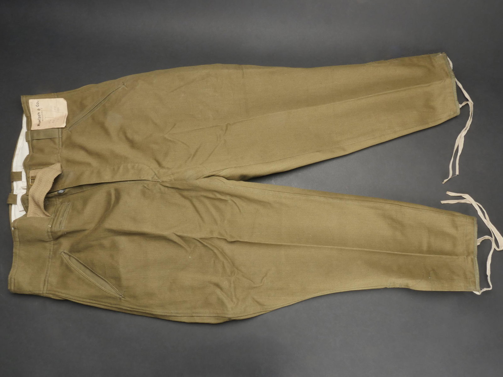 Pantalon tropical allemand. German tropical pants.: Pantalon tropical allemand. Modele culotte de cheval en tissu kaki cotele. Tous les boutons sont presents. Ceinture en toile complete. Boucle a trois ardillons en couleur d origine a 90%. Les lacets a