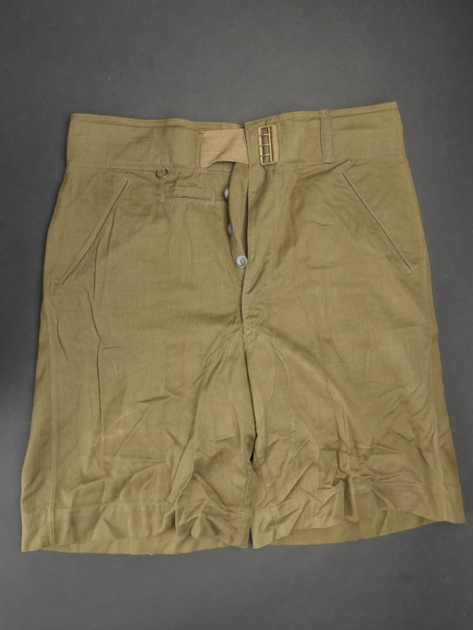 Short tropical. Tropical shorts.: Short tropical allemand. En forte toile kaki. Tous les boutons sont presents. Ceinture complete. Boucle a trois ardillons complete dans sa peinture d origine a 80%. Tres grande taille. Interieur doubl