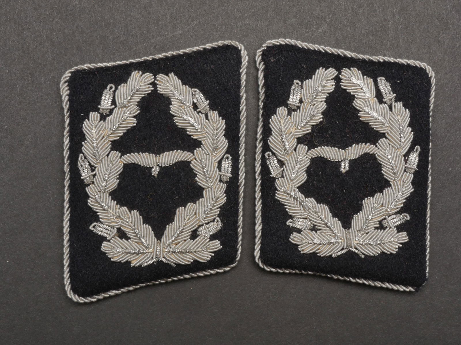 Pattes de col pionnier LW. Pioneer collar tabs LW.: Pattes de col de pionnier de la Luftwaffe. Paire homogene en drap noir typique des unites de pionnier, grade de Major en cannetille argent. A noter une certaine usure et patine des pieces. Etat II+. P