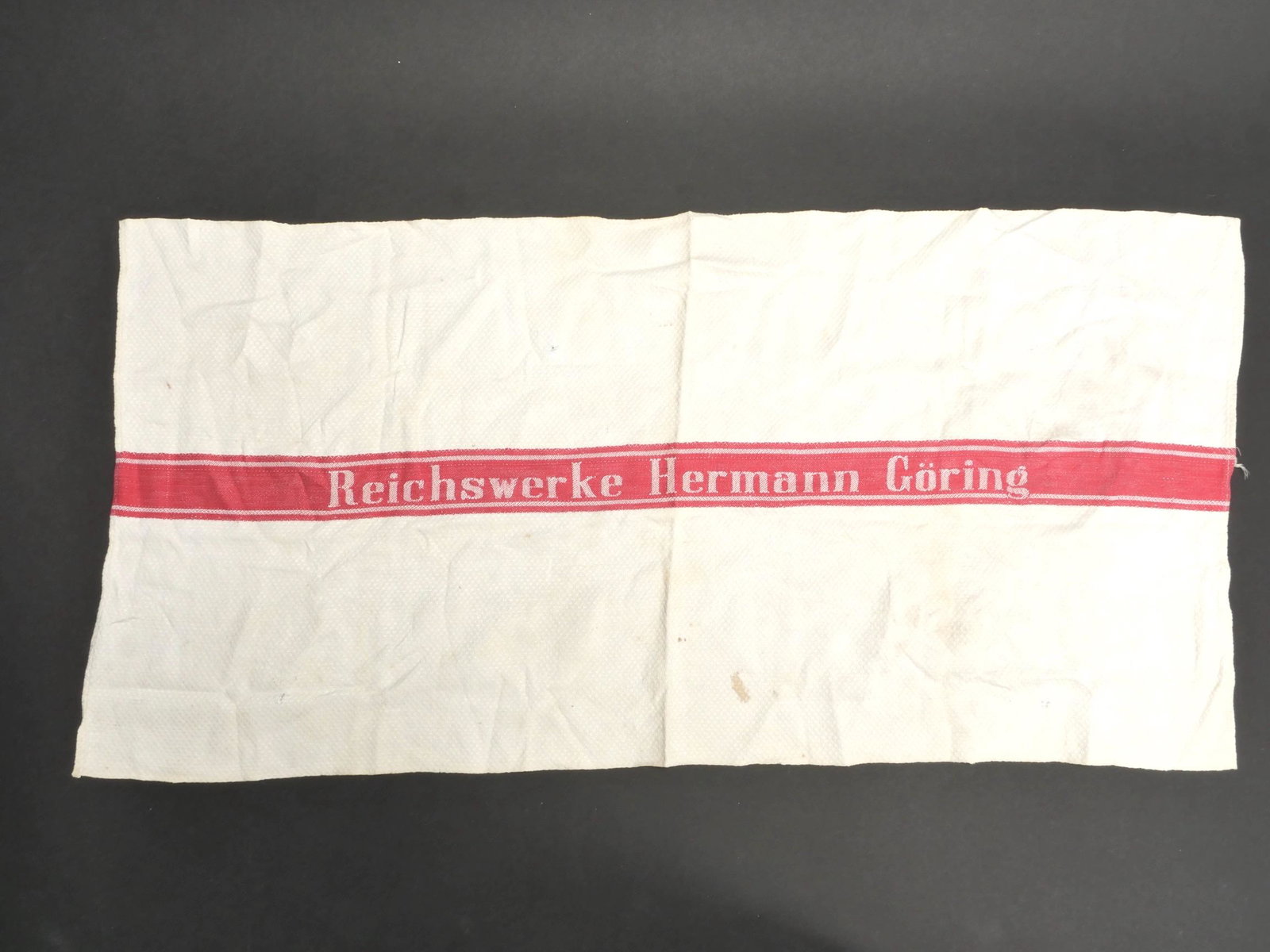 Serviette Hermann Goring. Hermann Goring towel.: Serviette Hermann Goring. En tissu nid d abeille blanc. Bande rouge centrale bien marquee Reichswerke Hermann Goring. A noter une certaine usure et patine de la piece, ainsi que quelques t aches. Etat