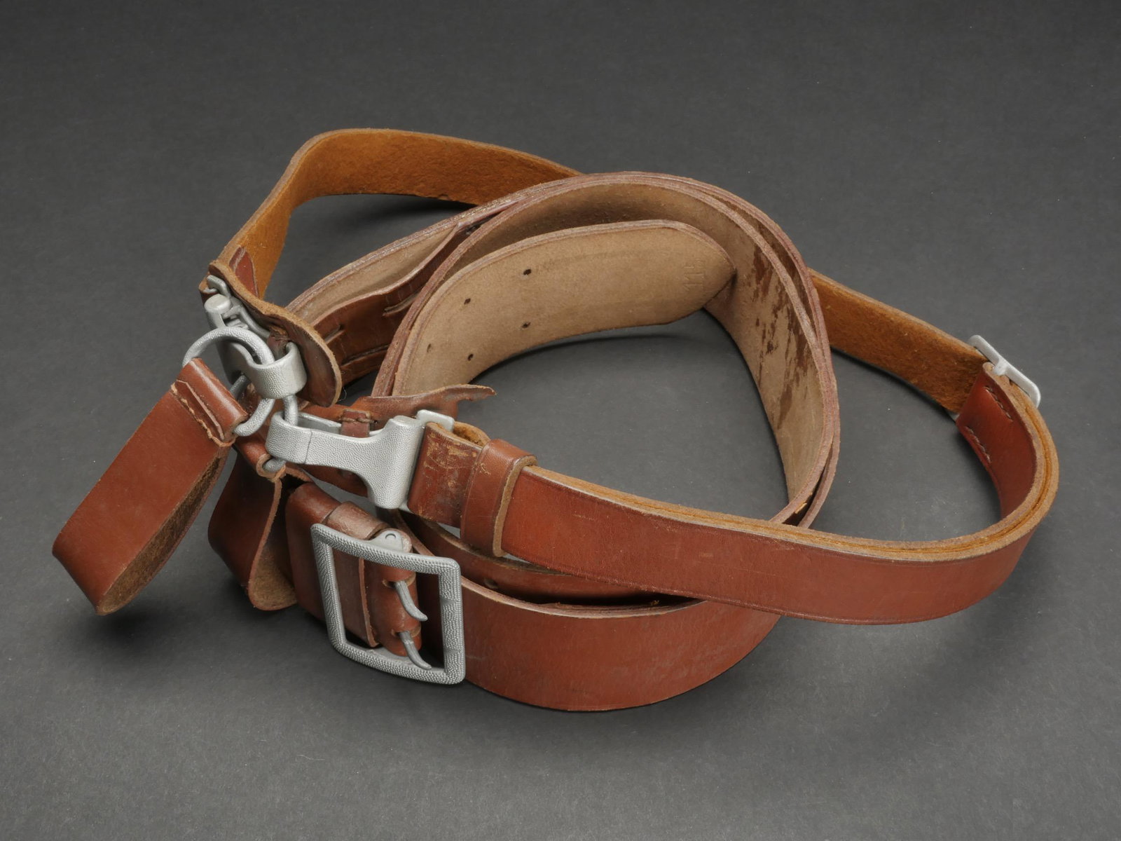 Ceinturon d officier LW. Officer s belt LW.: Ceinturon d officier de la Luftwaffe. Ceinturon en cuir marron. Boucle a deux ardillons en metal grenele. Les deux passants de ceinturon sont presents. Baudrier en cuir marron, les deux mousquetons so