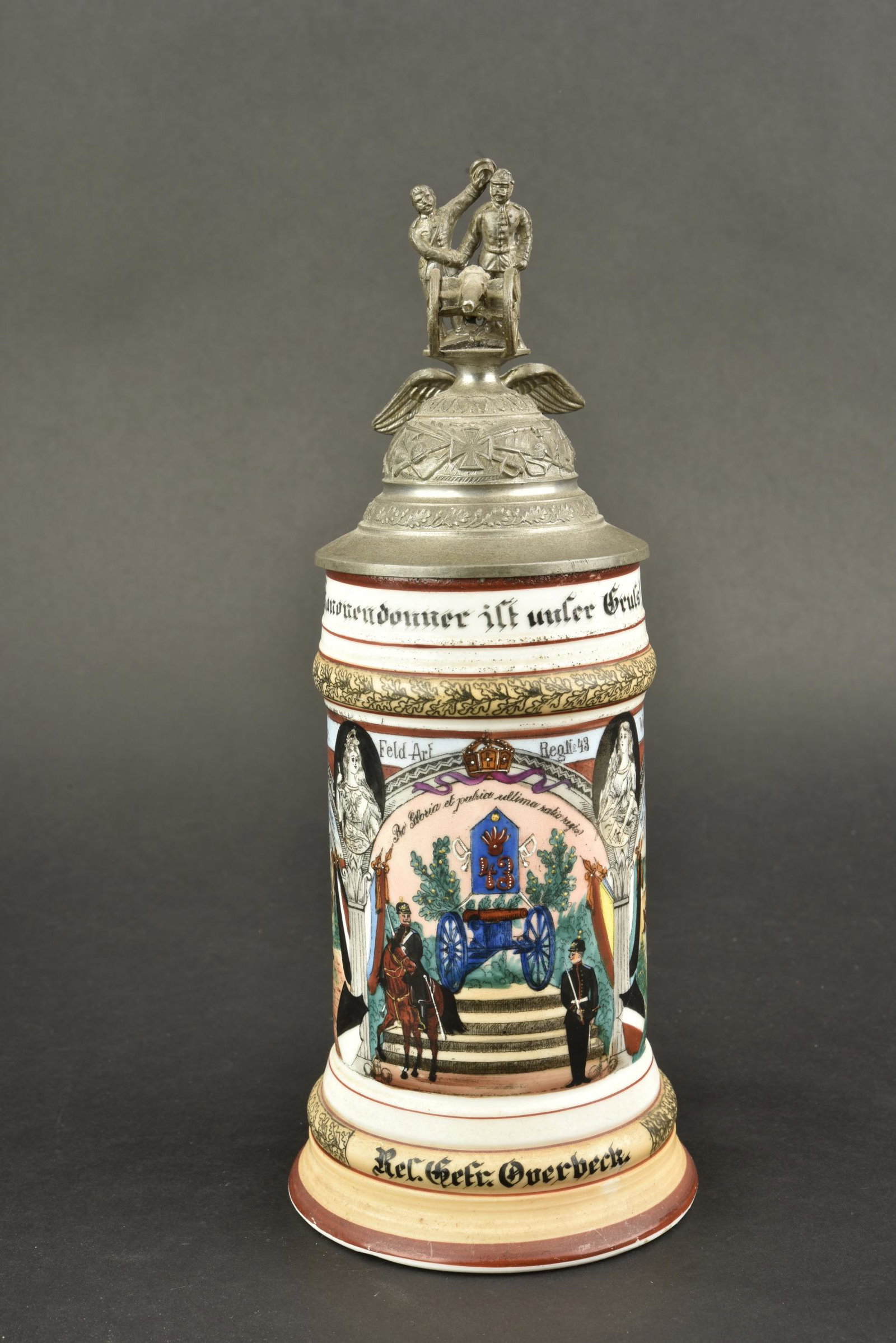 Chope de reserviste. Reserve mug.: Chope de reserviste. En porcelaine blanche. Couvercle surmonte d un canon et de ses servants. Beau decors partiellement en relief. Marquages Bd 6 Battr Feld Art Reg N 43 Wesel 1901-1903. Le decors sur